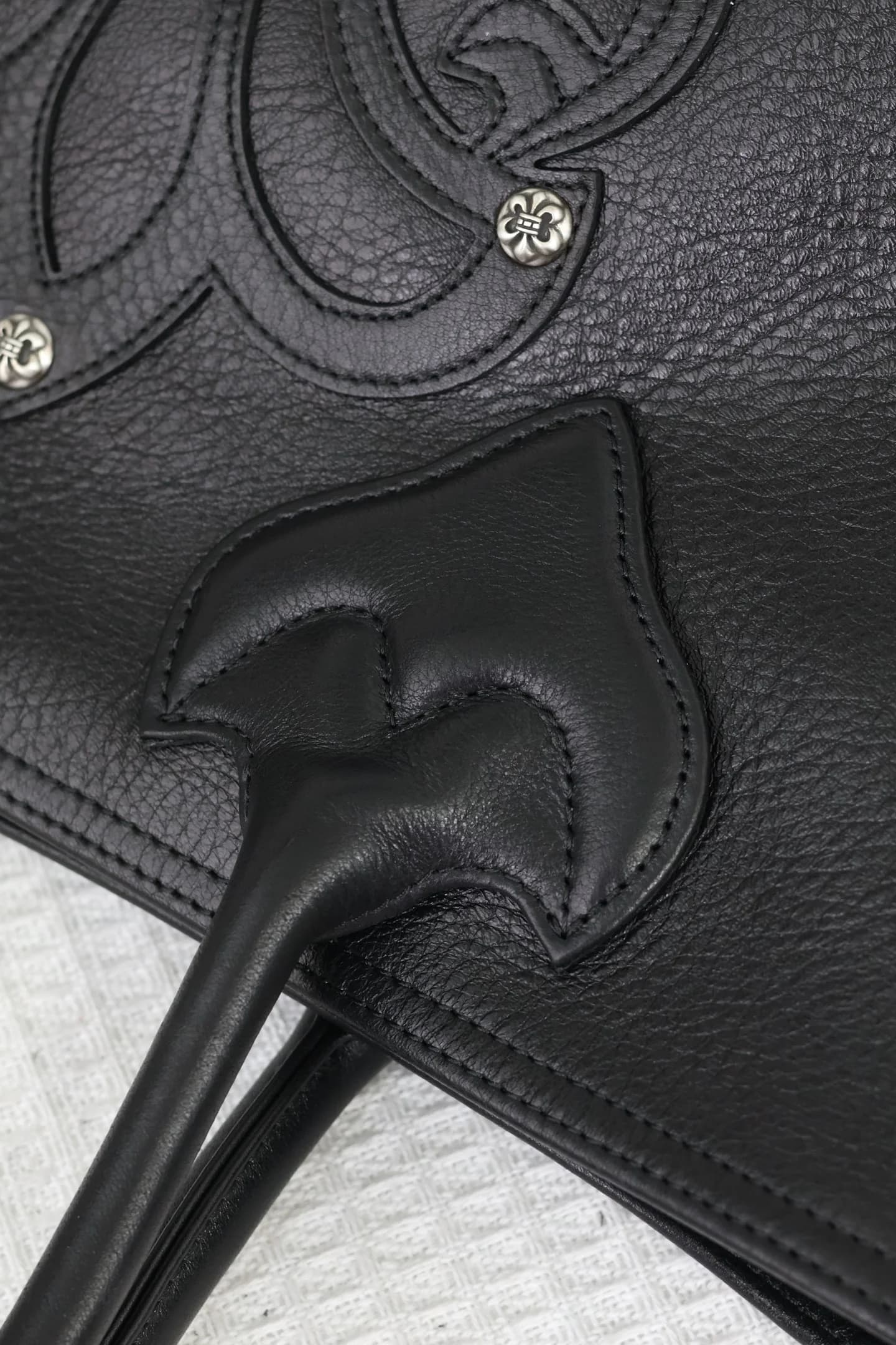 Деталь кожаного крепления ручки и декоративной строчки сумки Chrome Hearts