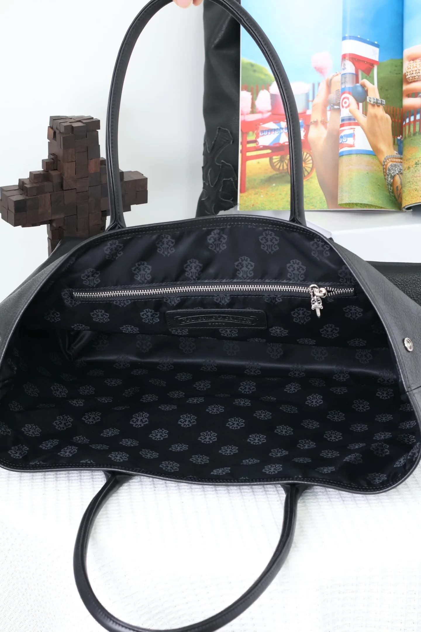 Вместительное внутреннее отделение сумки Chrome Hearts с фирменным узором подкладки