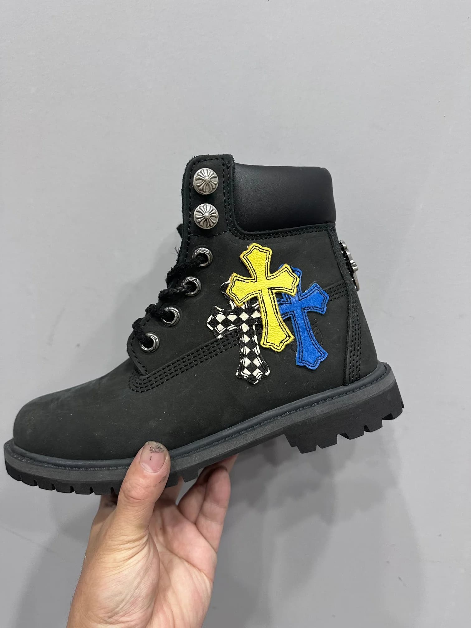 Боковая сторона ботинка Chrome Hearts x Timberland с желтым, синим и клетчатым крестами