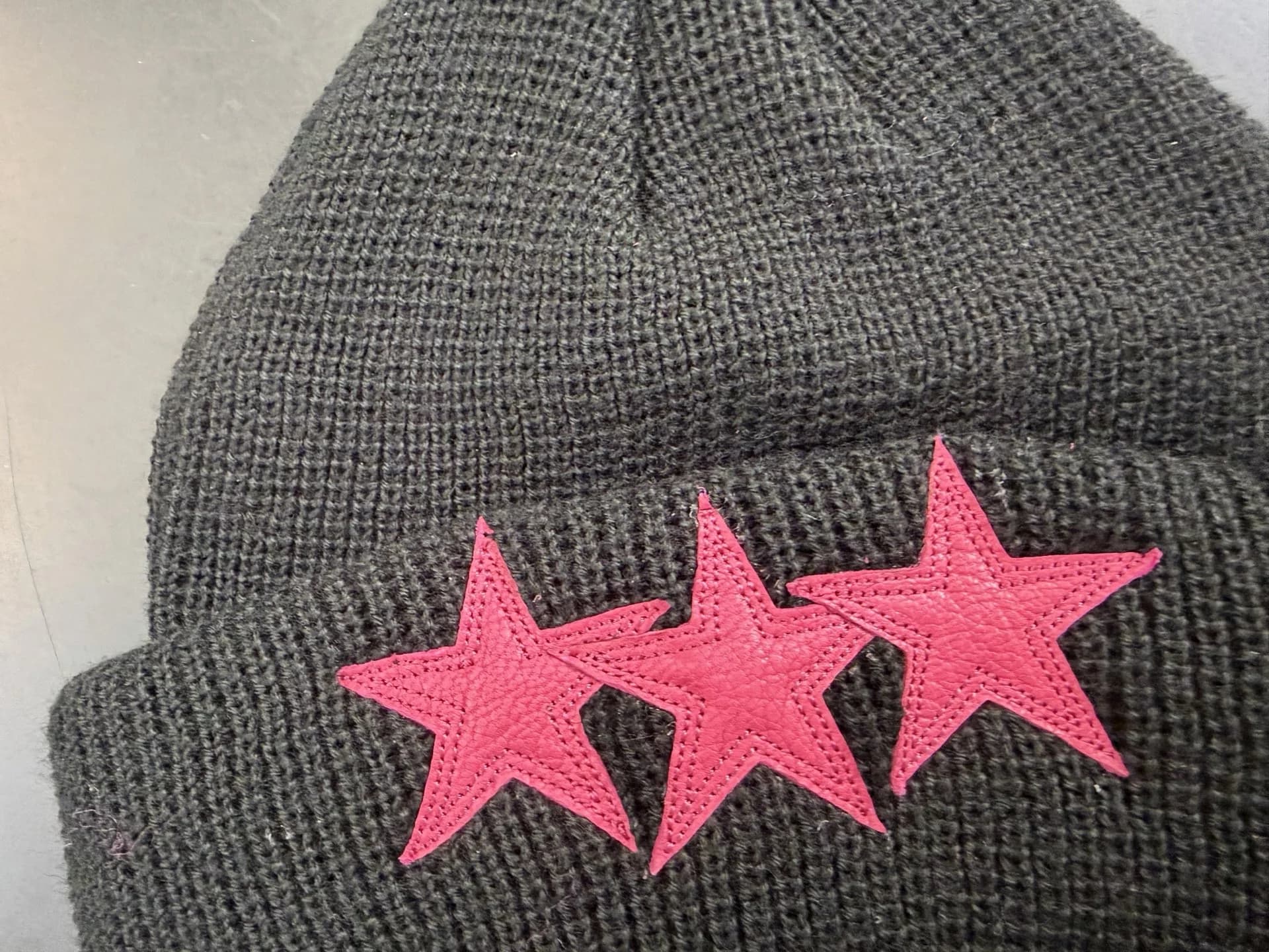 Деталь отворота шапки Chrome Hearts с розовыми кожаными звездами