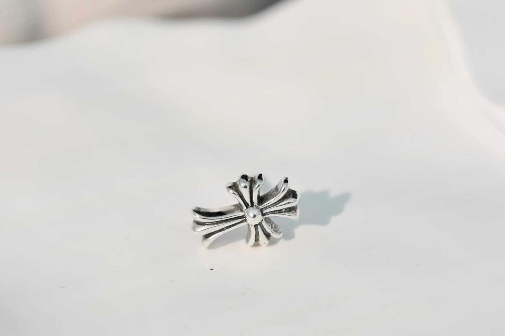 Серьга-гвоздик Chrome Hearts Cross крупным планом с рельефным узором