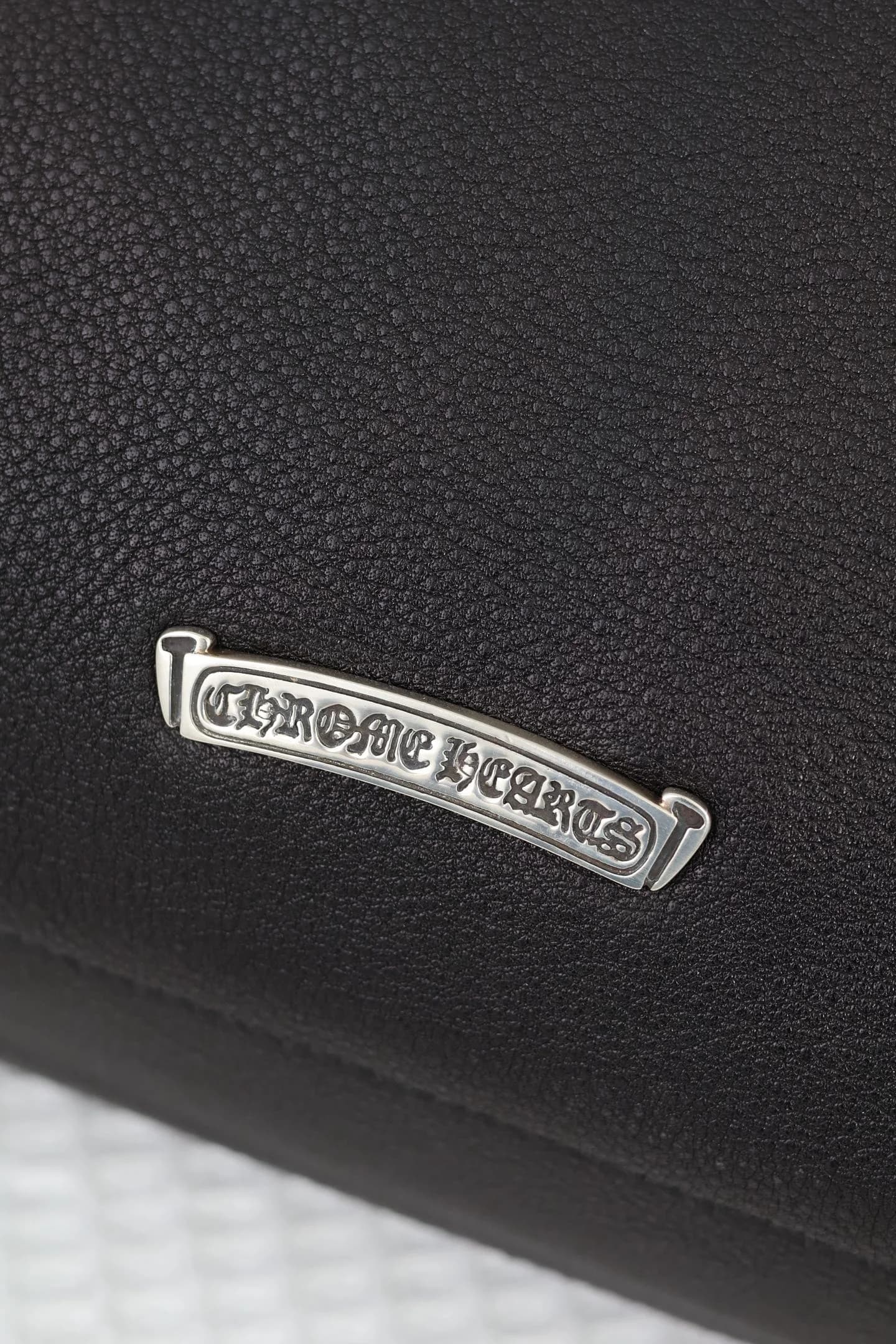 Серебряный металлический логотип Chrome Hearts на задней стороне сумки