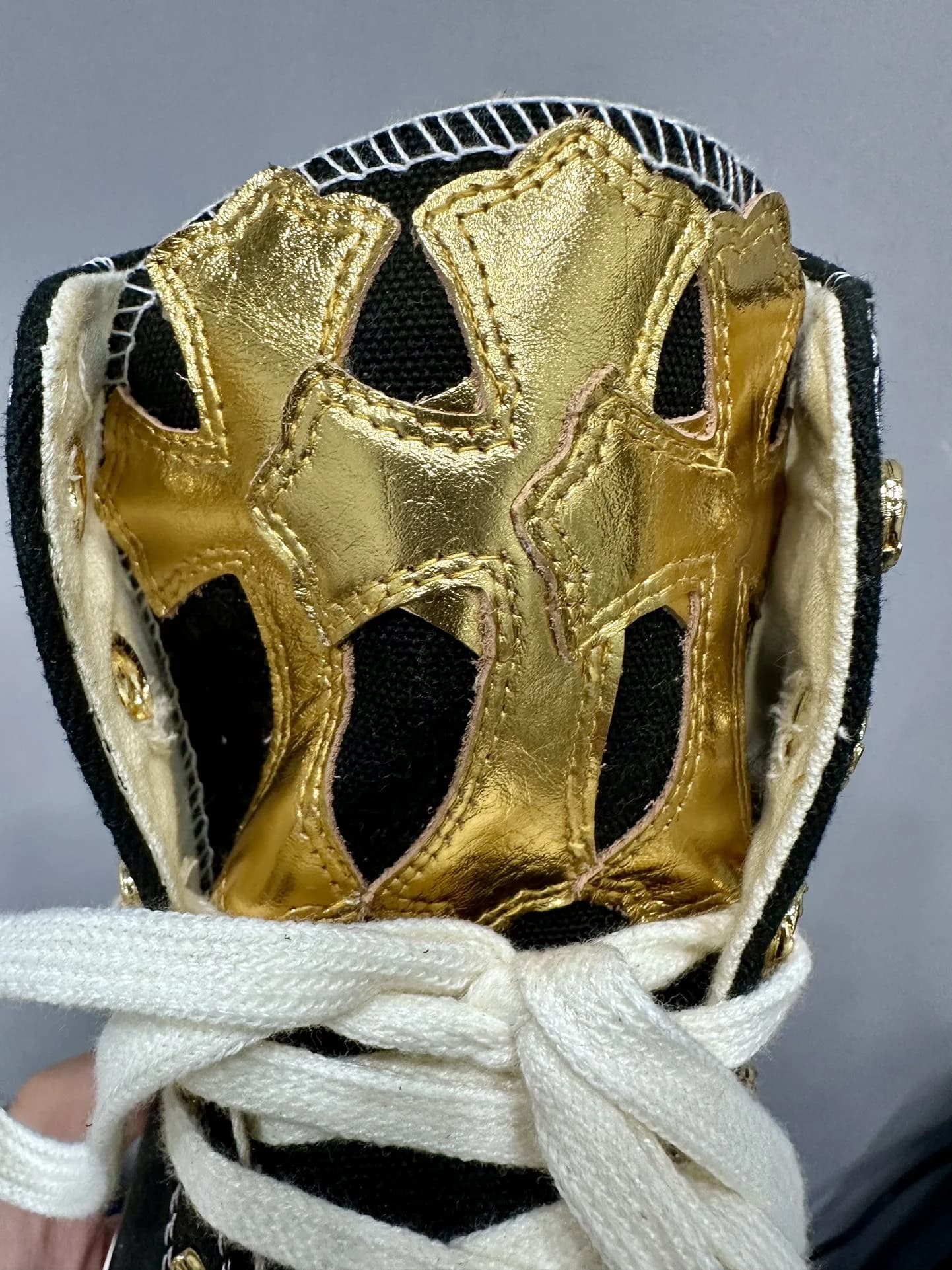 Деталь язычка кед Chrome Hearts x Converse с золотистыми кожаными крестами