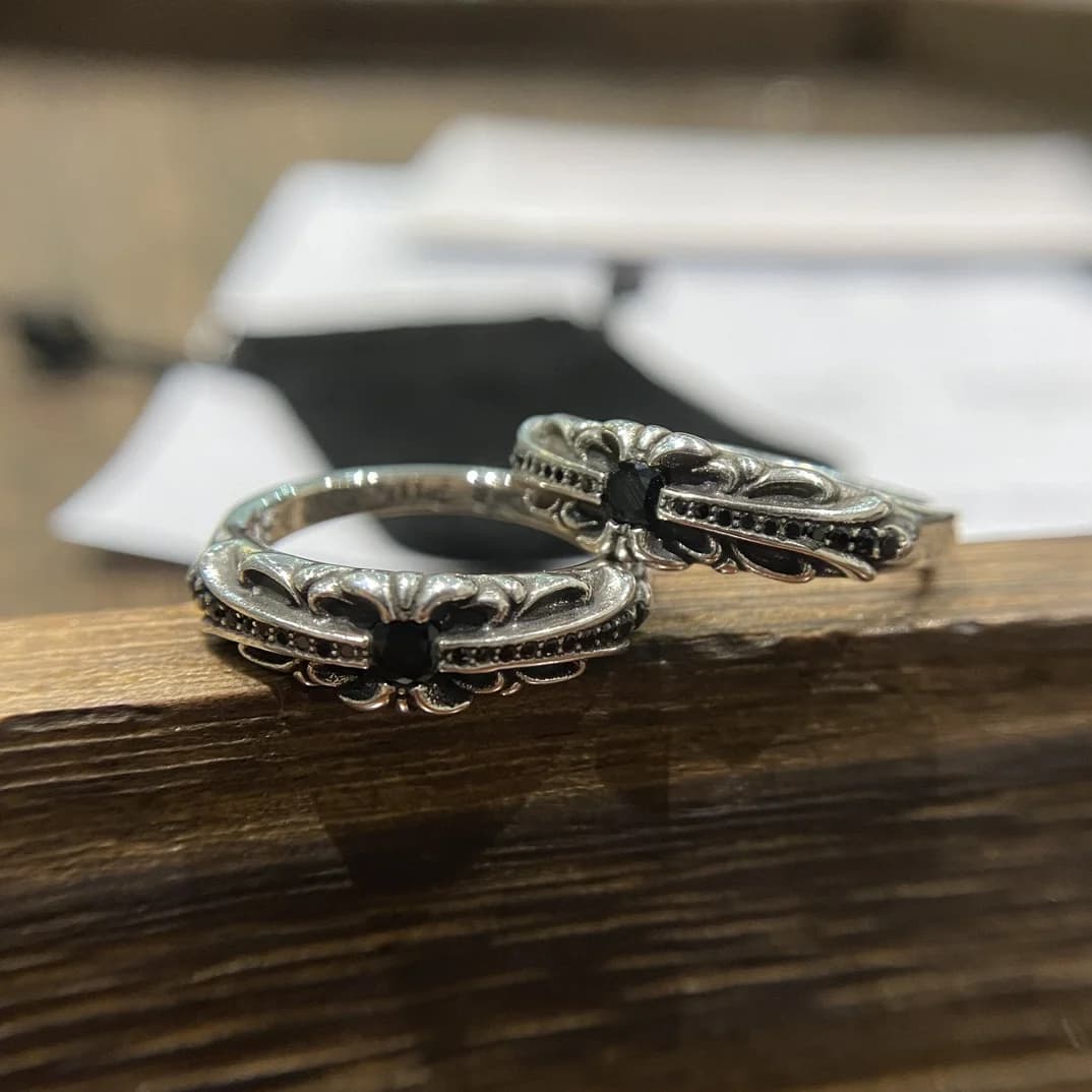 Два серебряных кольца Chrome Hearts Baby Floral на деревянной поверхности