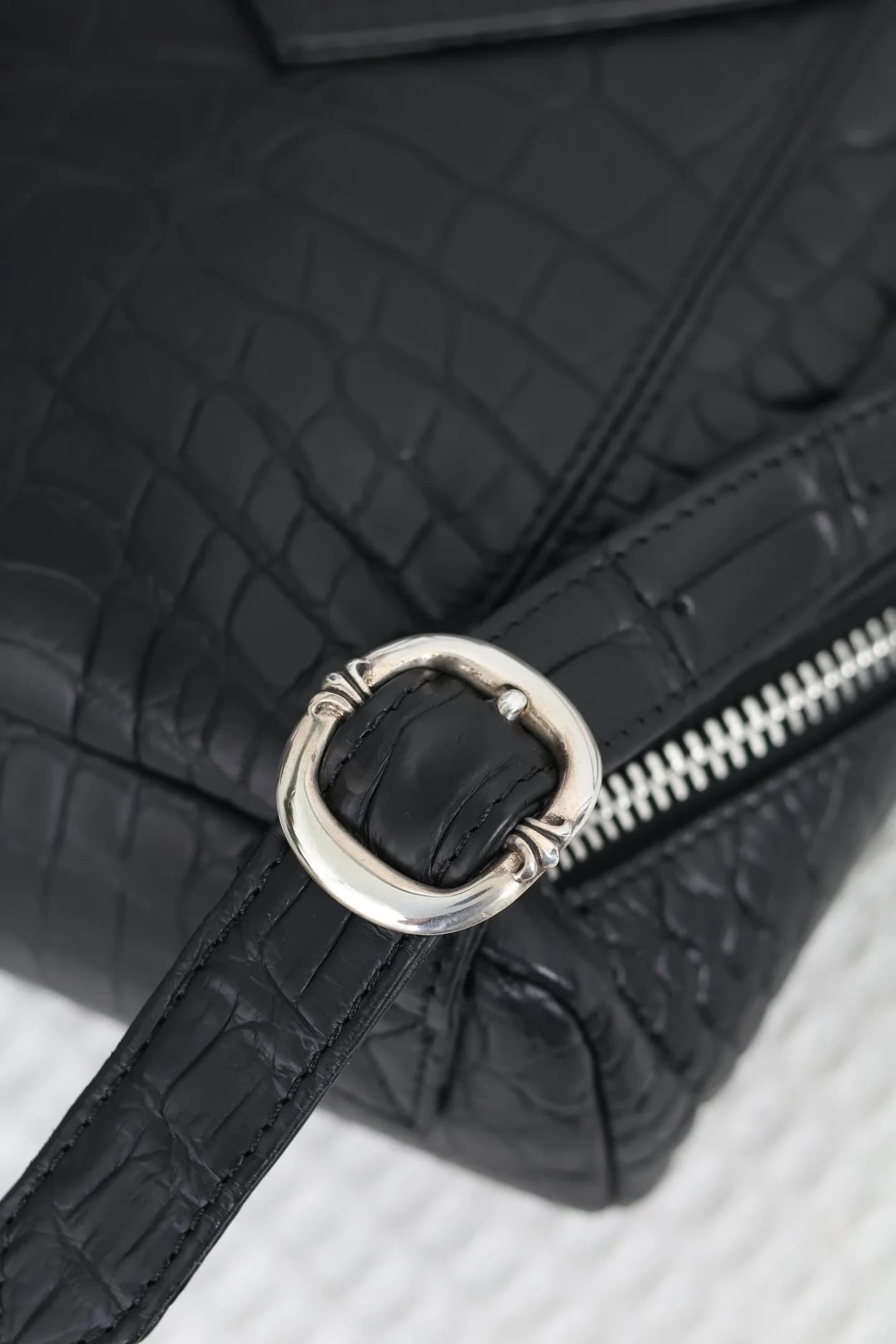 Крупный план серебряного кольца крепления лямки рюкзака Chrome Hearts