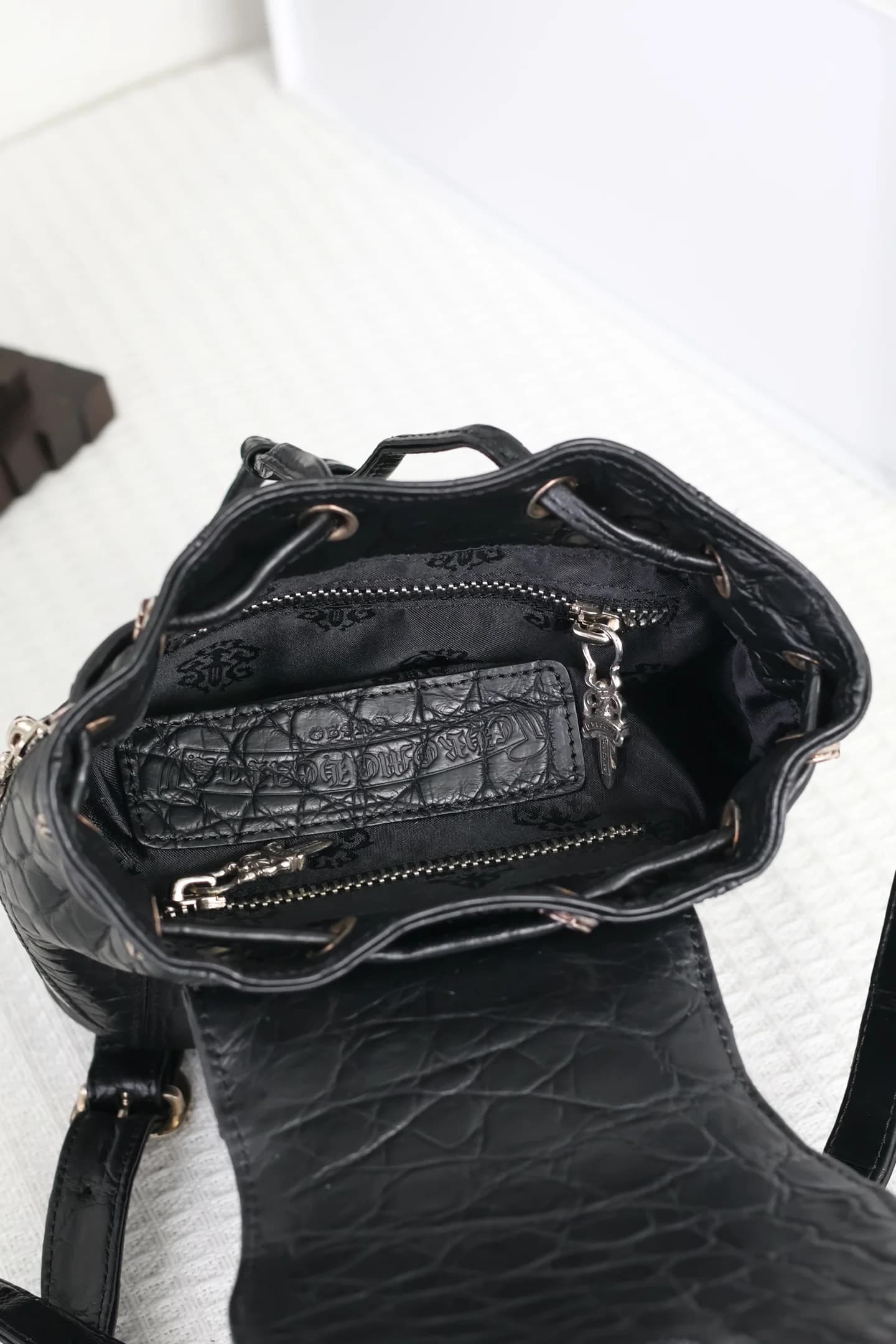 Внутреннее отделение мини-рюкзака Chrome Hearts с жаккардовой подкладкой и карманом