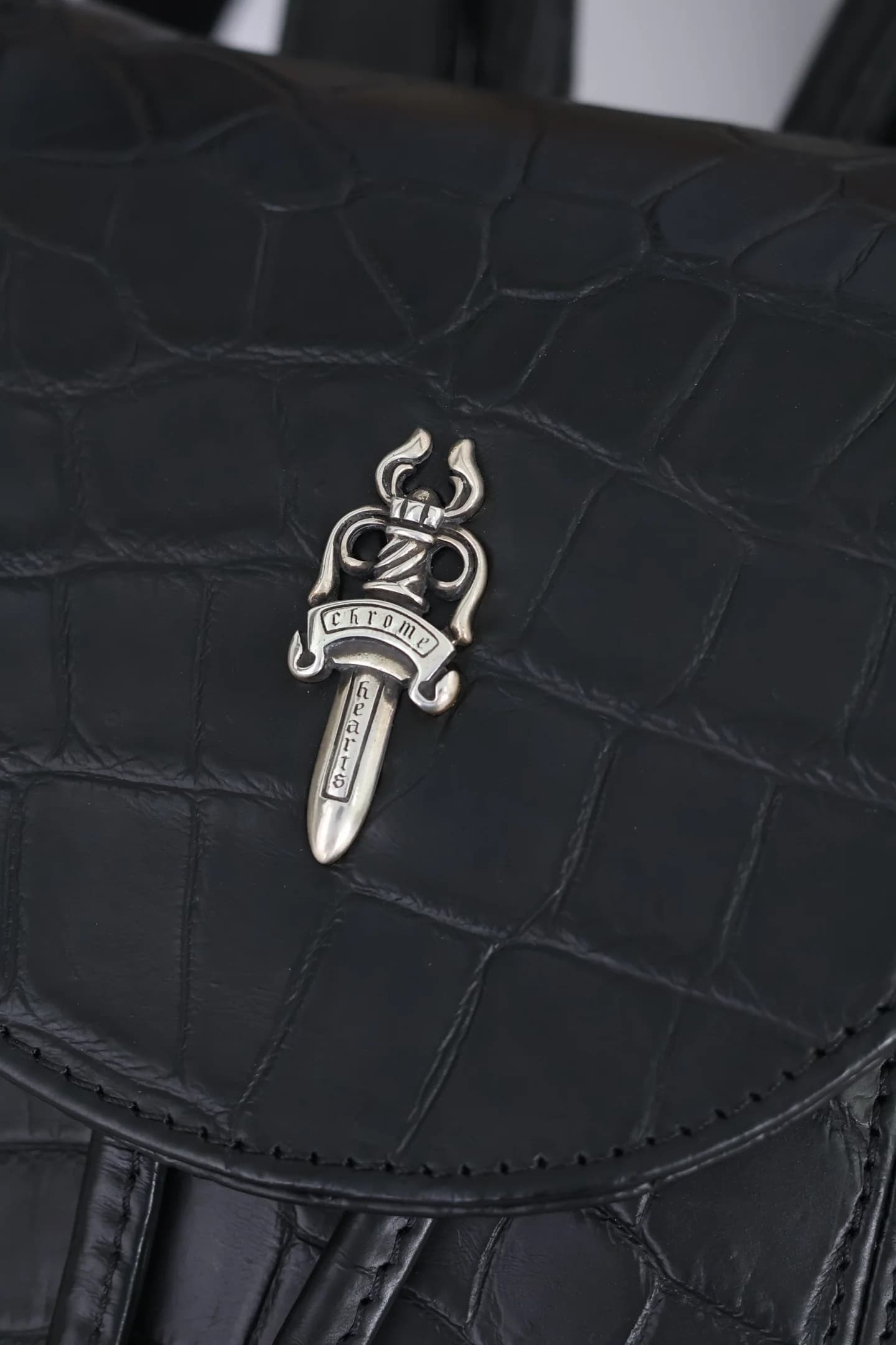 Деталь серебряного декора в виде кинжала Dagger на клапане рюкзака Chrome Hearts