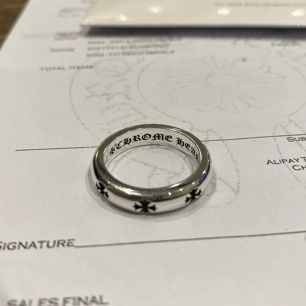 Серебряное кольцо Chrome Hearts Cross Band под углом на фоне квитанции