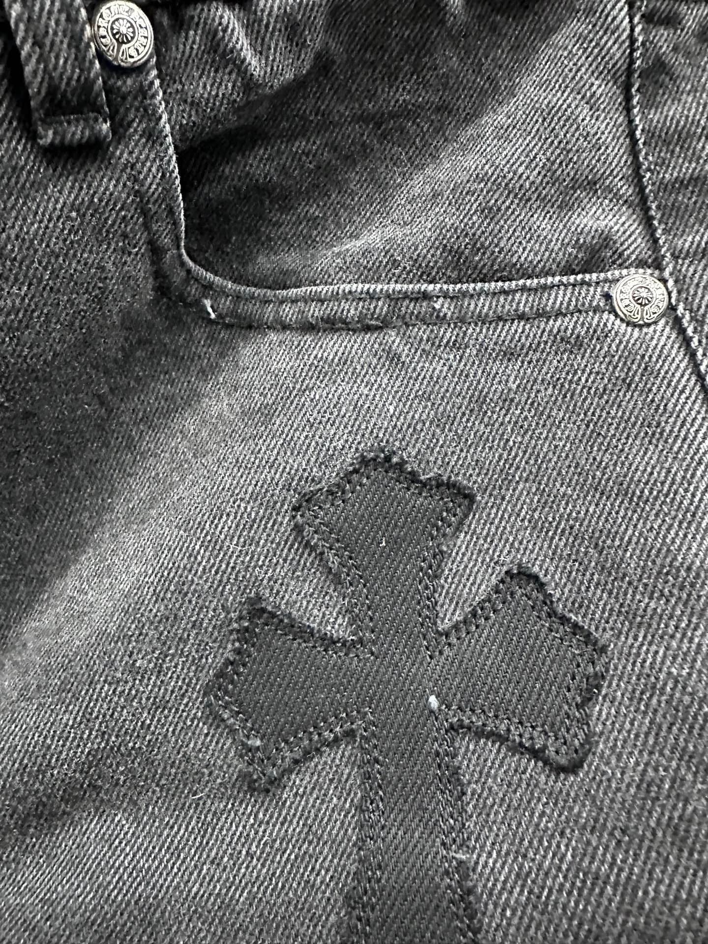 Деталь кожаной нашивки в виде креста на джинсах Chrome Hearts