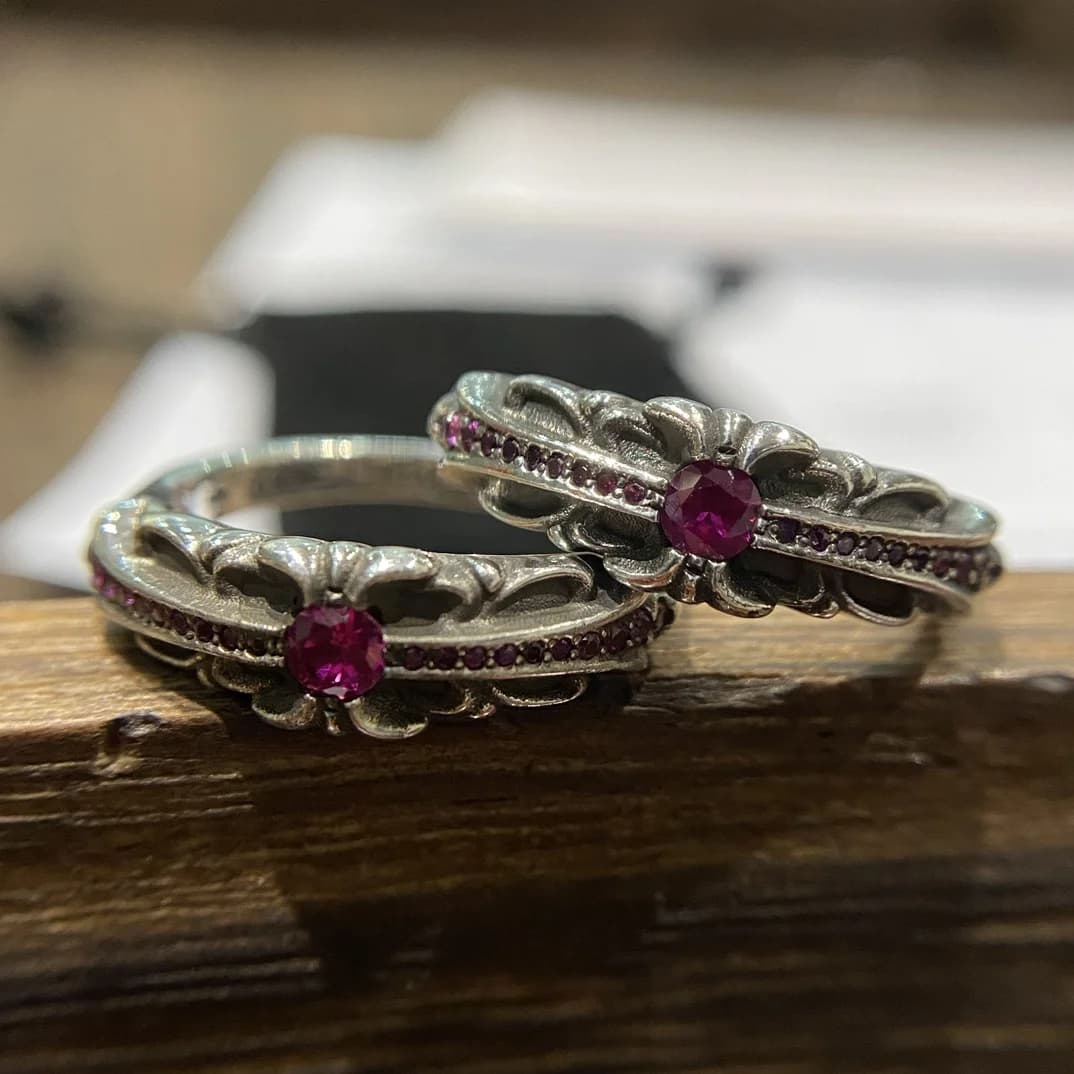 Пара колец Chrome Hearts Baby Floral с красными камнями на деревянной подставке