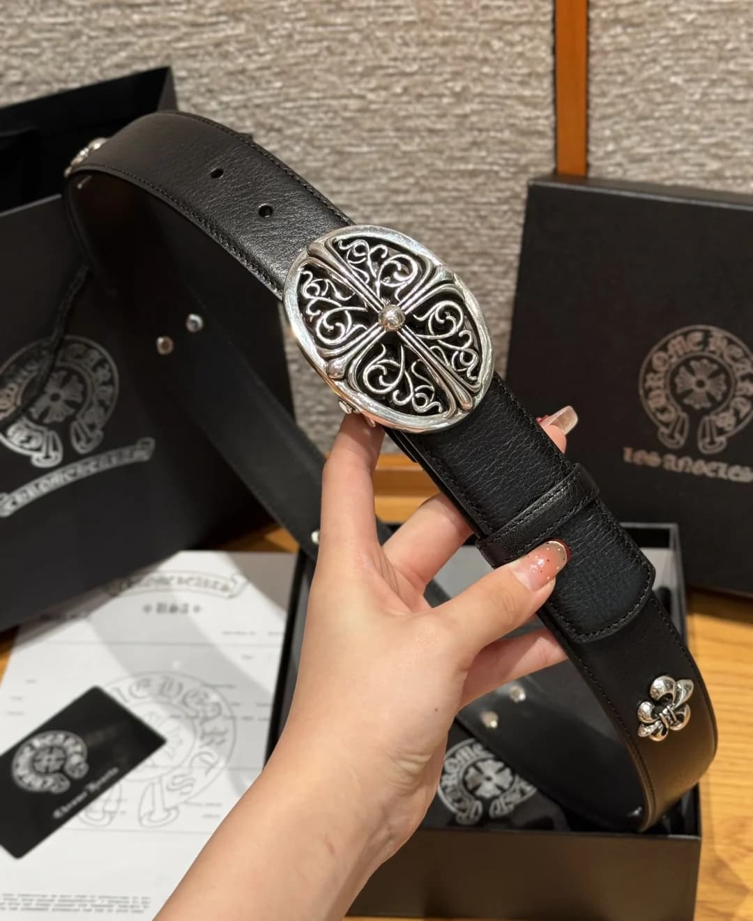 Ремень Chrome Hearts с пряжкой в готическом стиле в руке
