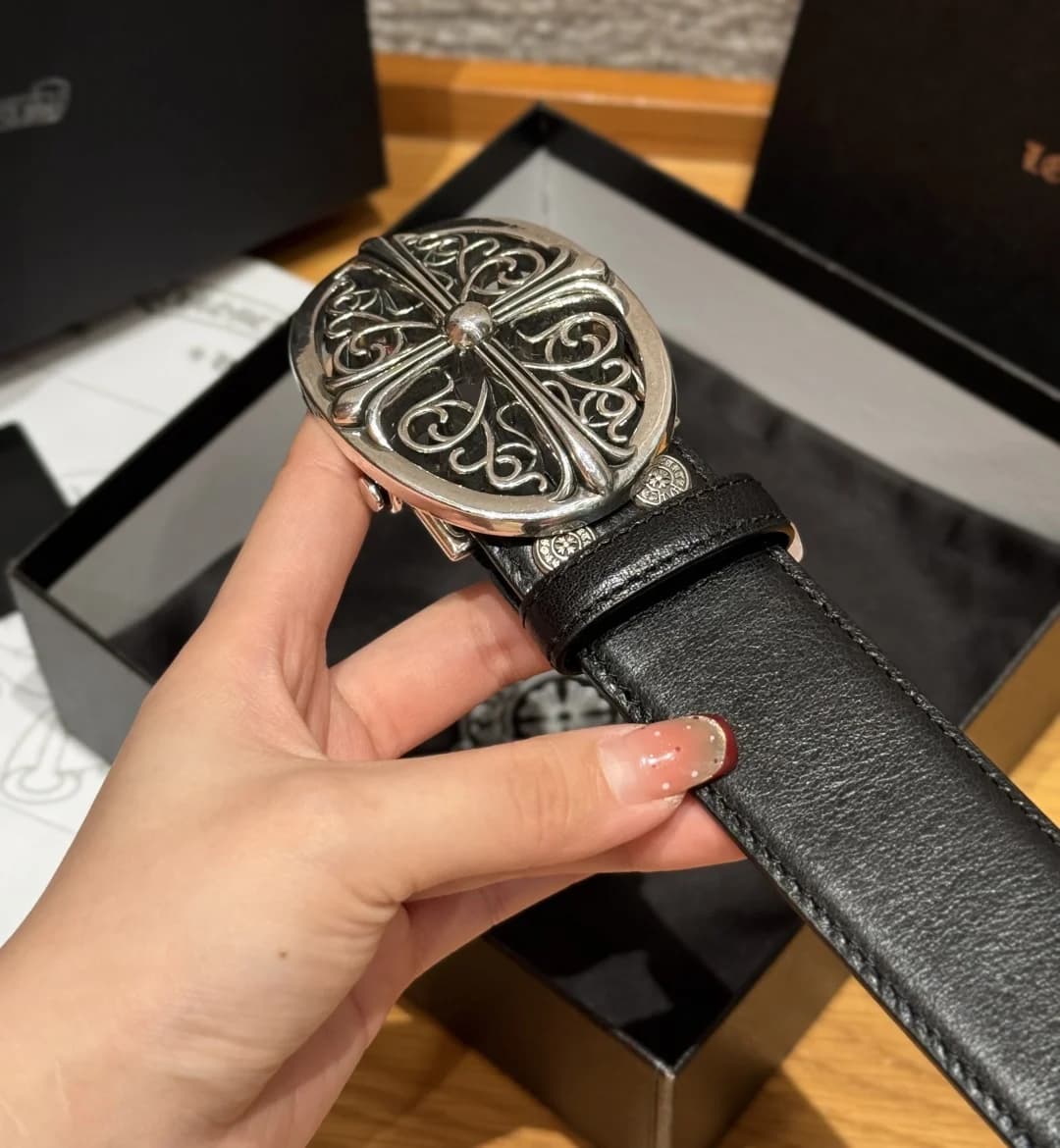 Крупный план овальной пряжки ремня Chrome Hearts с резным узором