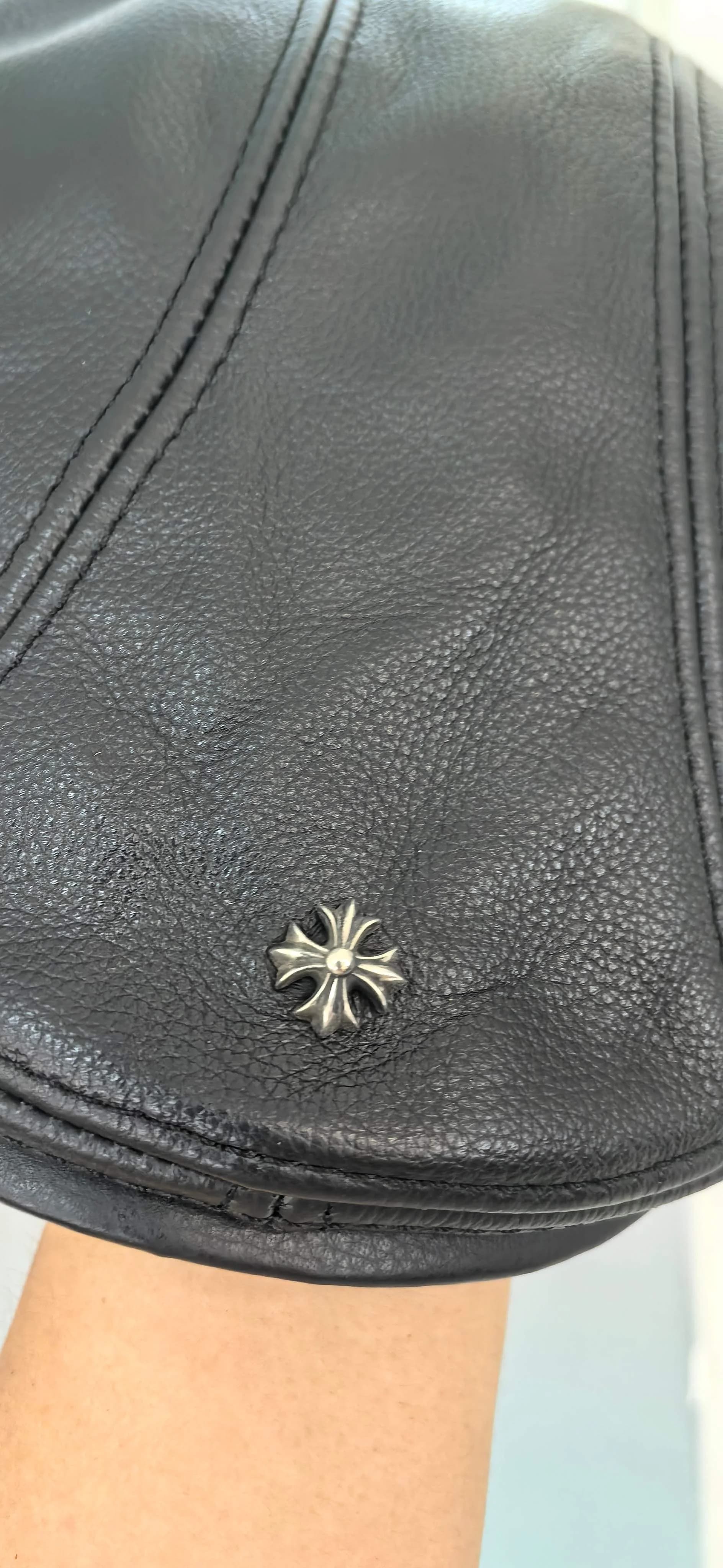 Деталь козырька кожаной кепки Chrome Hearts с заклепкой-крестом