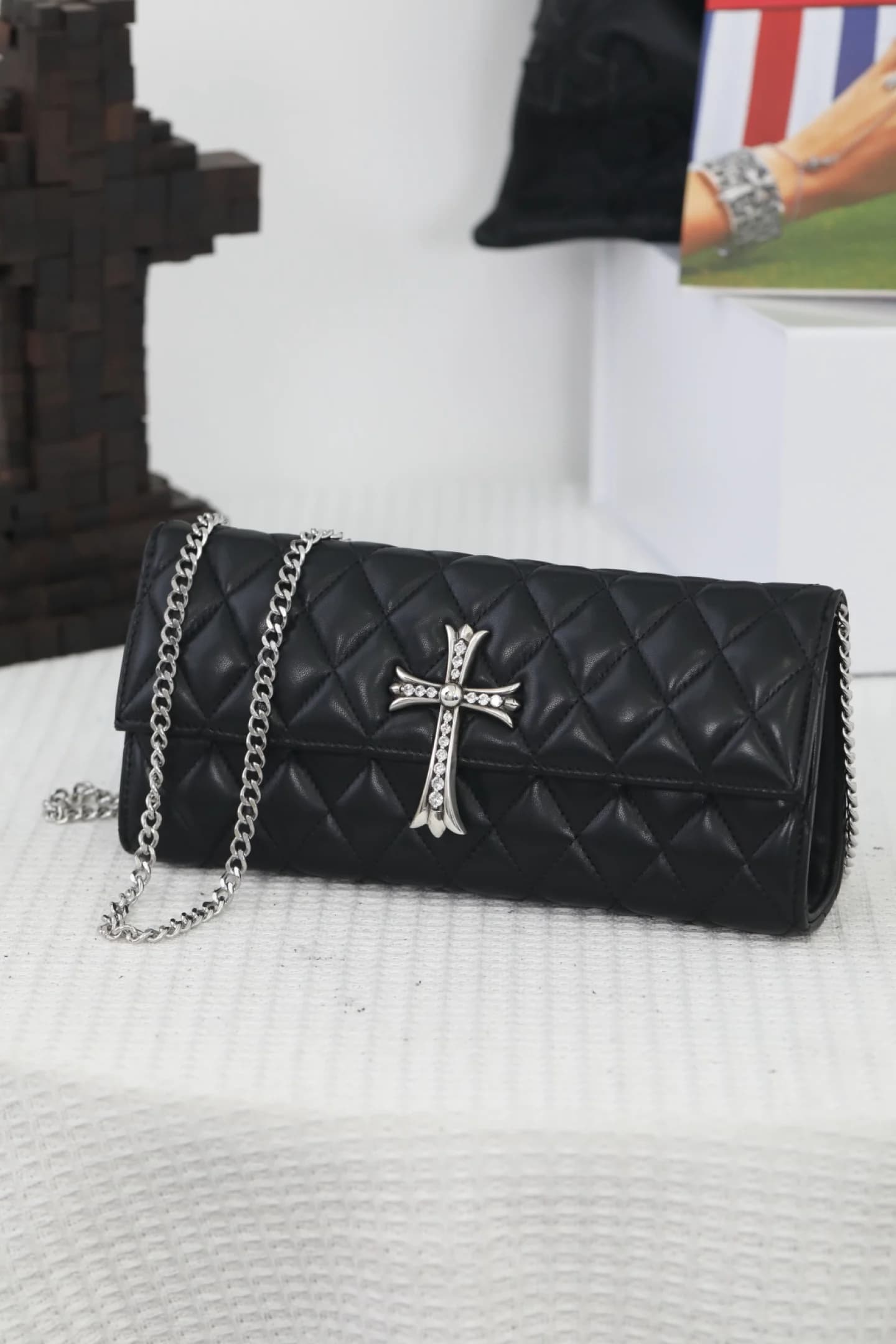 Чёрный кожаный клатч Chrome Hearts со съёмной цепочкой на столе
