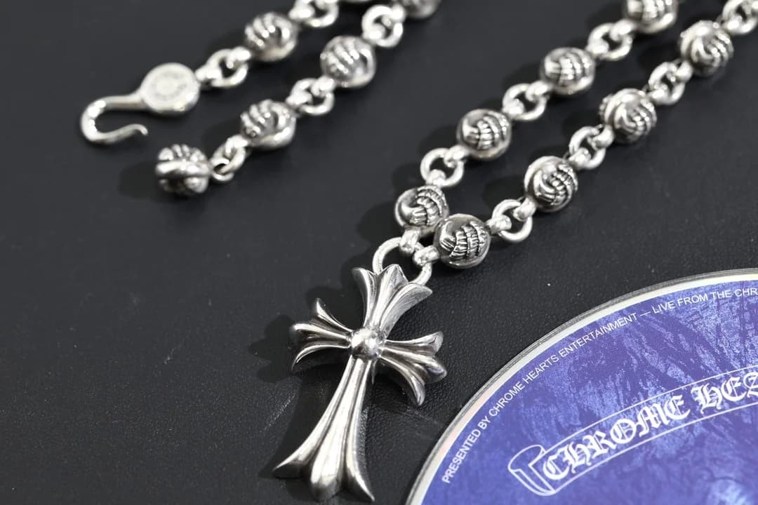 Колье Chrome Hearts с подвеской-крестом и застежкой на темном фоне