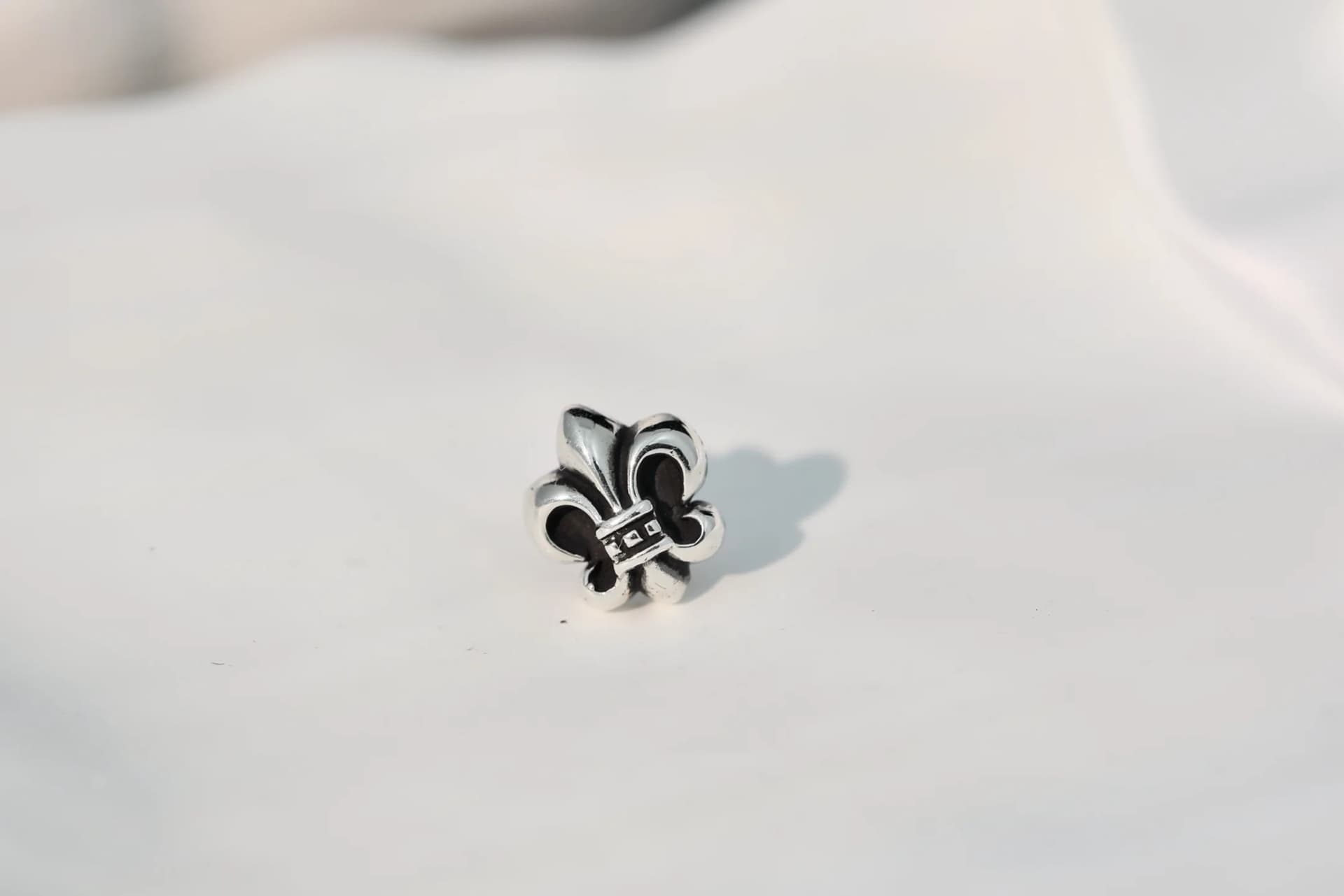 Серьга-пусет Chrome Hearts в форме геральдической лилии крупным планом
