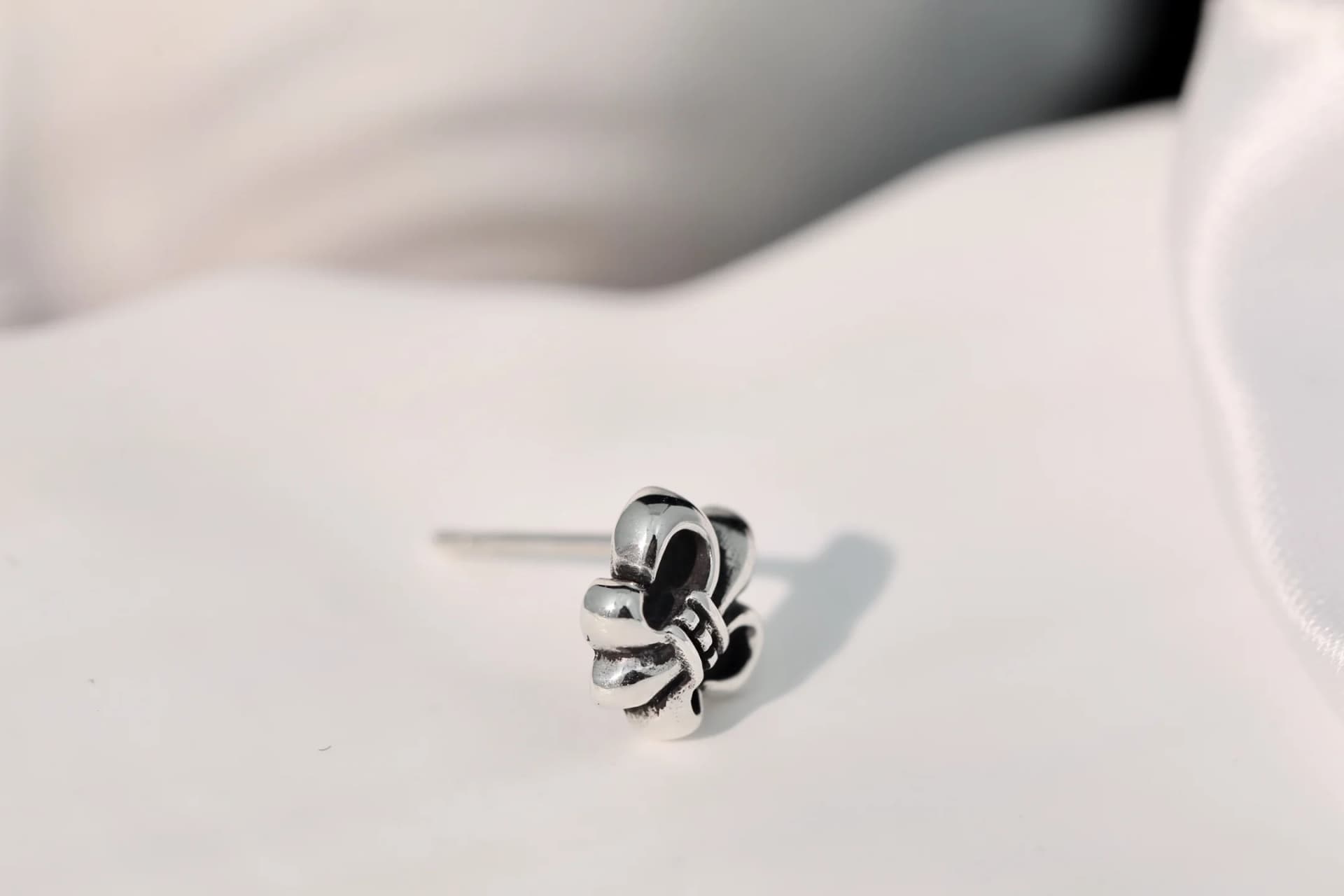Серьга Chrome Hearts BS Fleur под углом на светлой поверхности