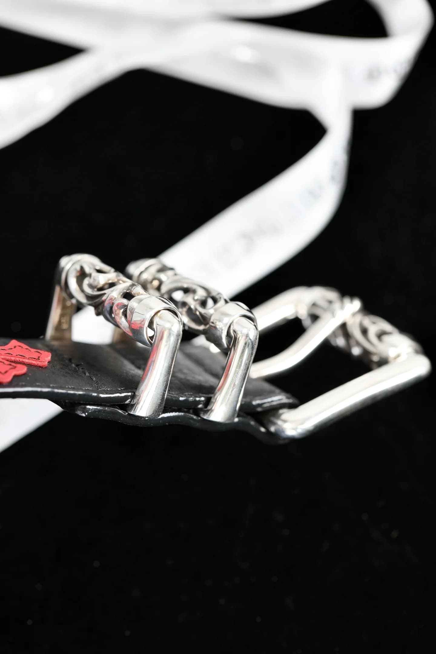 Вид сбоку на массивные серебряные шлёвки и пряжку ремня Chrome Hearts