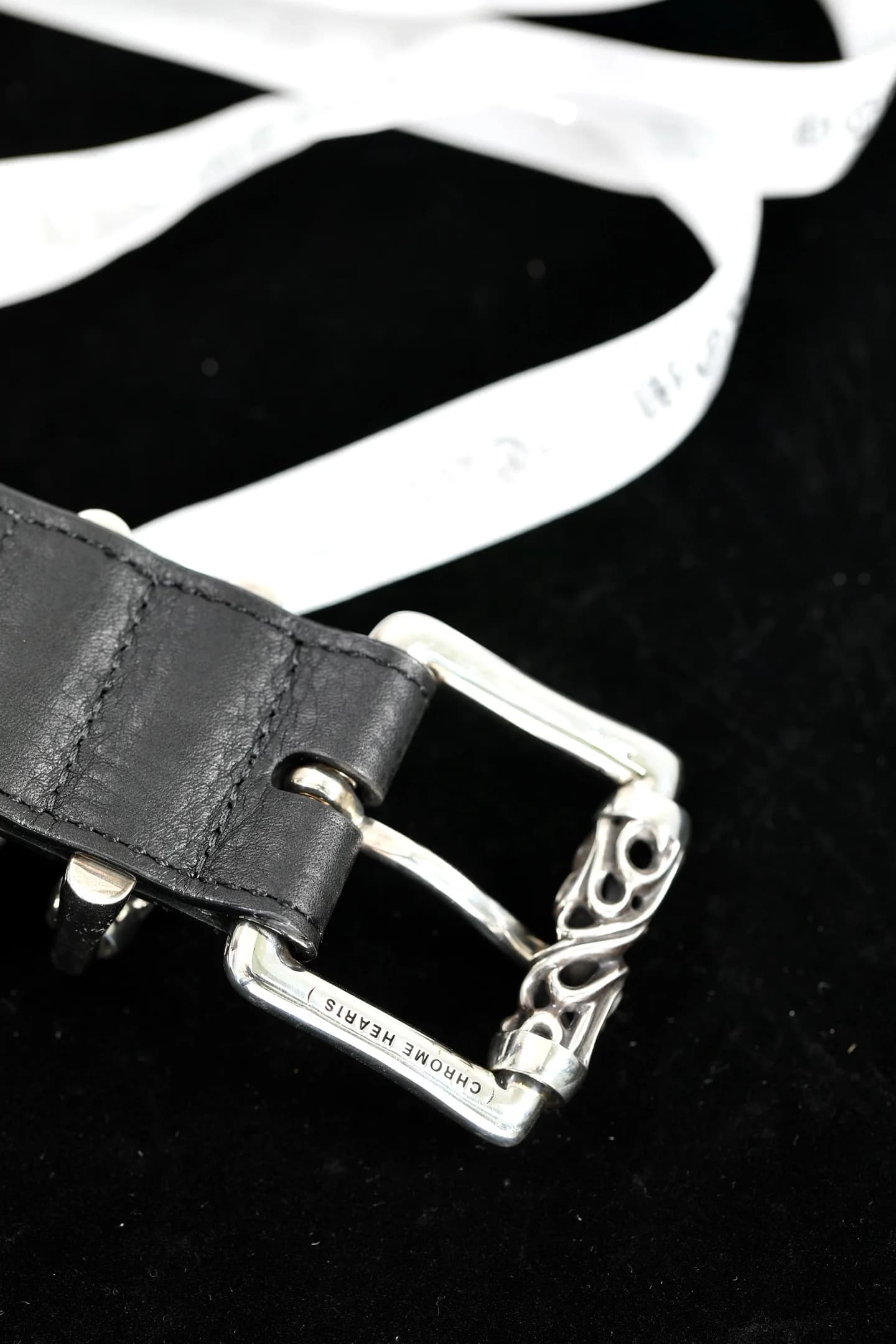 Гравировка Chrome Hearts на серебряной пряжке ремня крупным планом