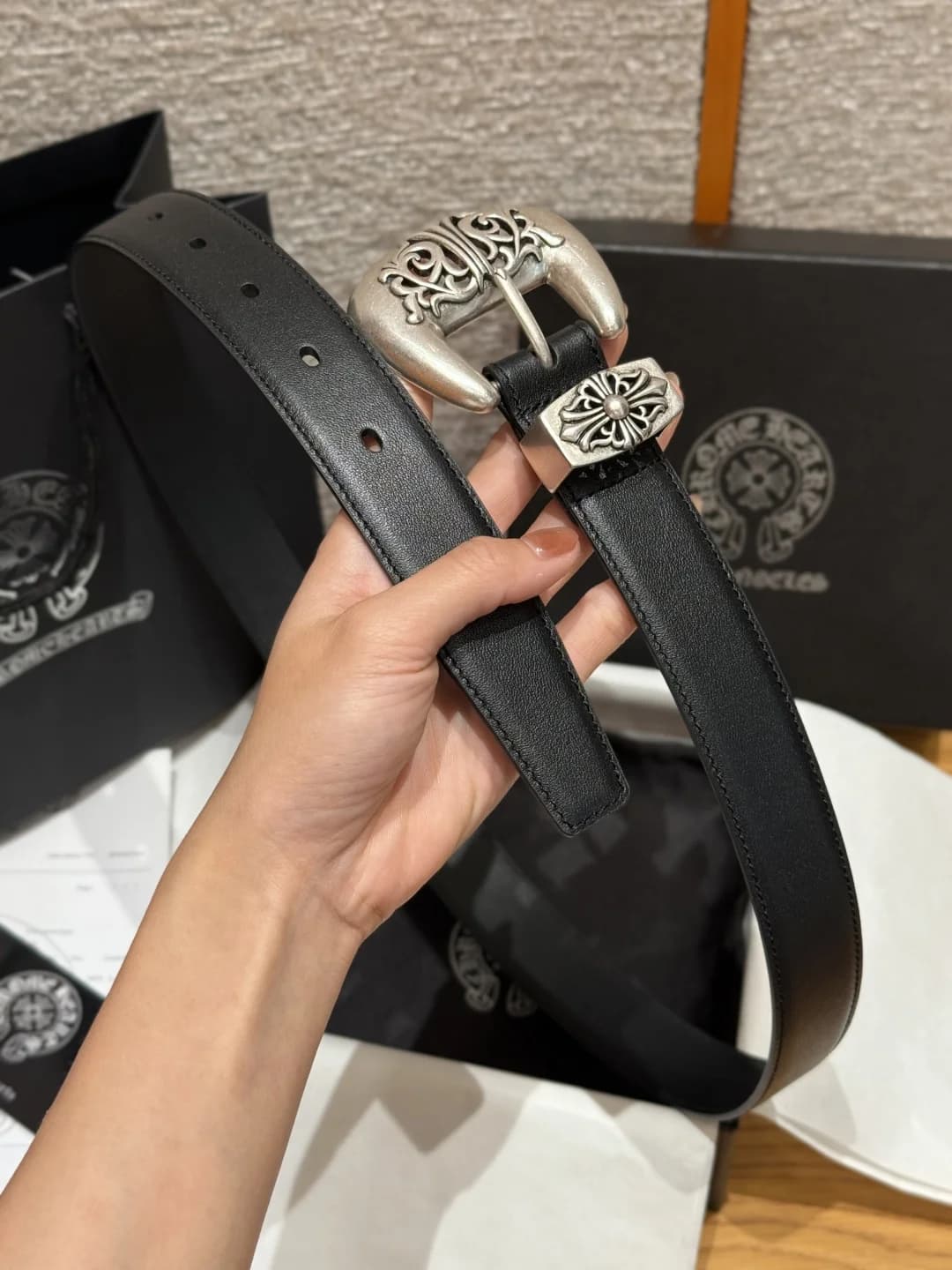 Черный мужской ремень Chrome Hearts в руке