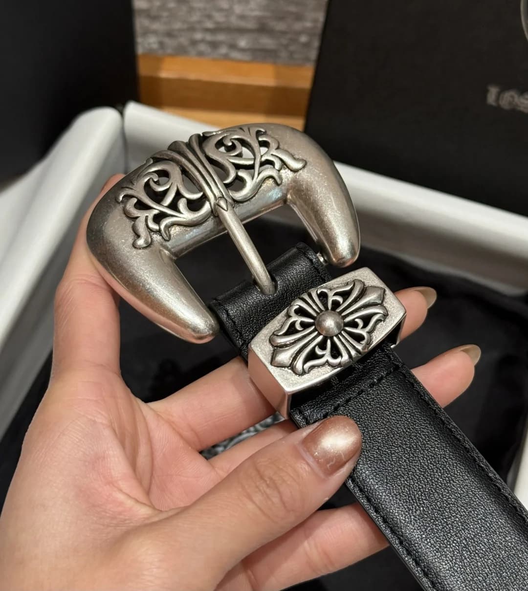 Крупный план резной пряжки и шлевки с крестом ремня Chrome Hearts