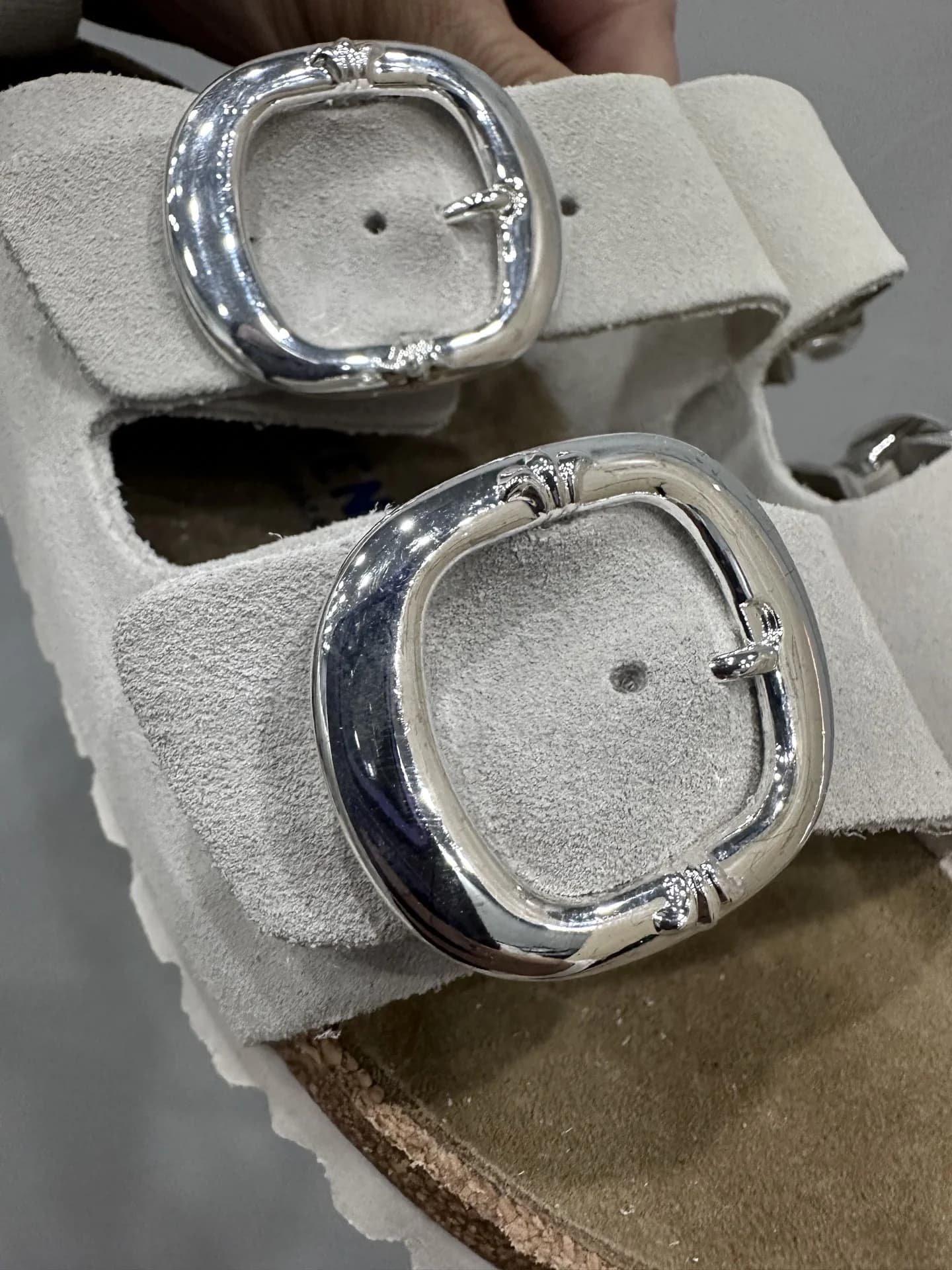 Крупный план серебряных пряжек шлепанцев Chrome Hearts x Birkenstock Arizona