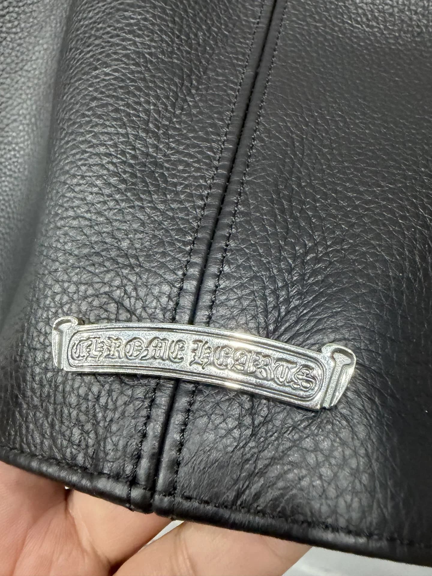 Серебряная пластина с логотипом Chrome Hearts на подоле куртки