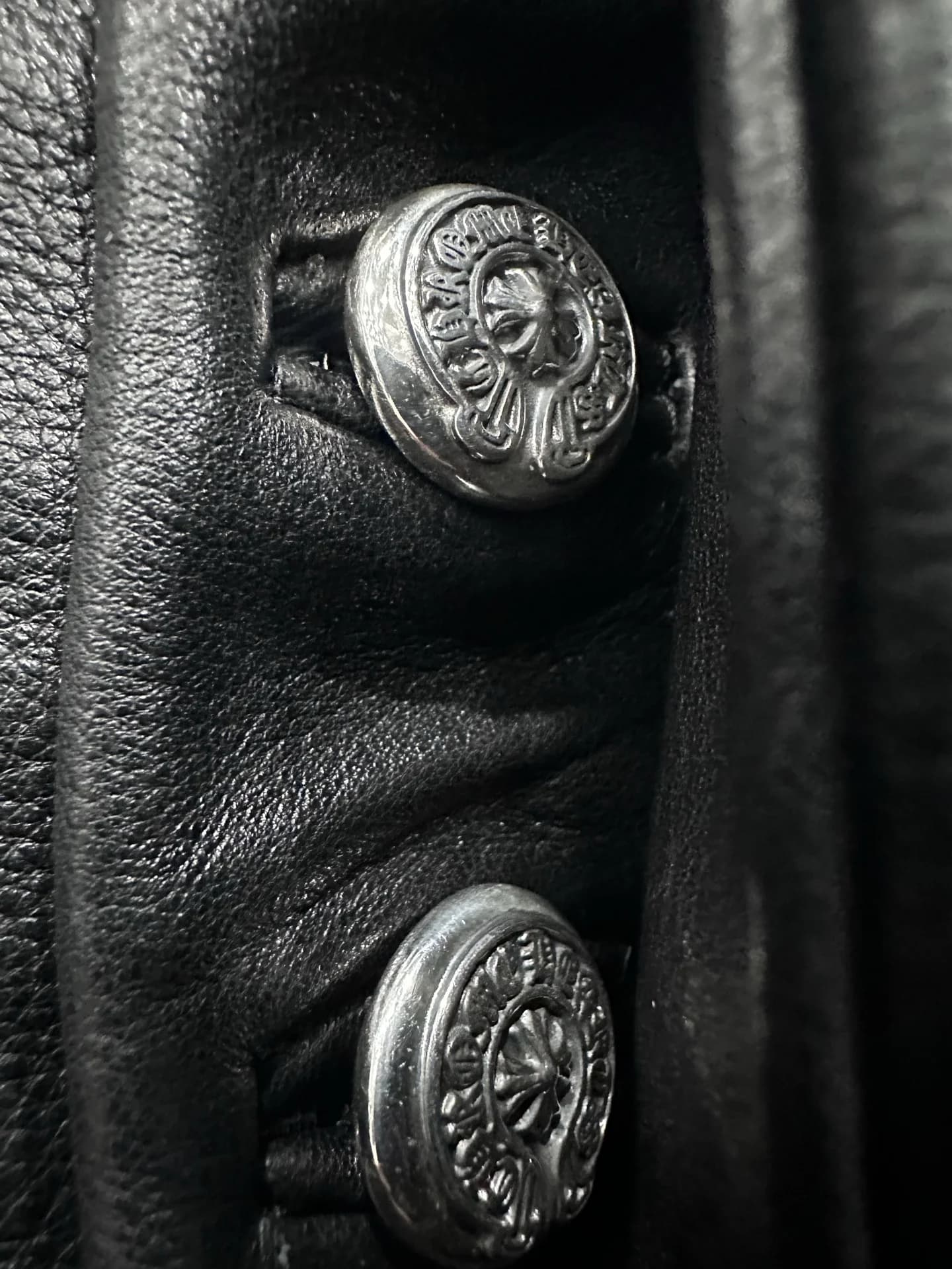 Крупный план серебряных пуговиц Chrome Hearts