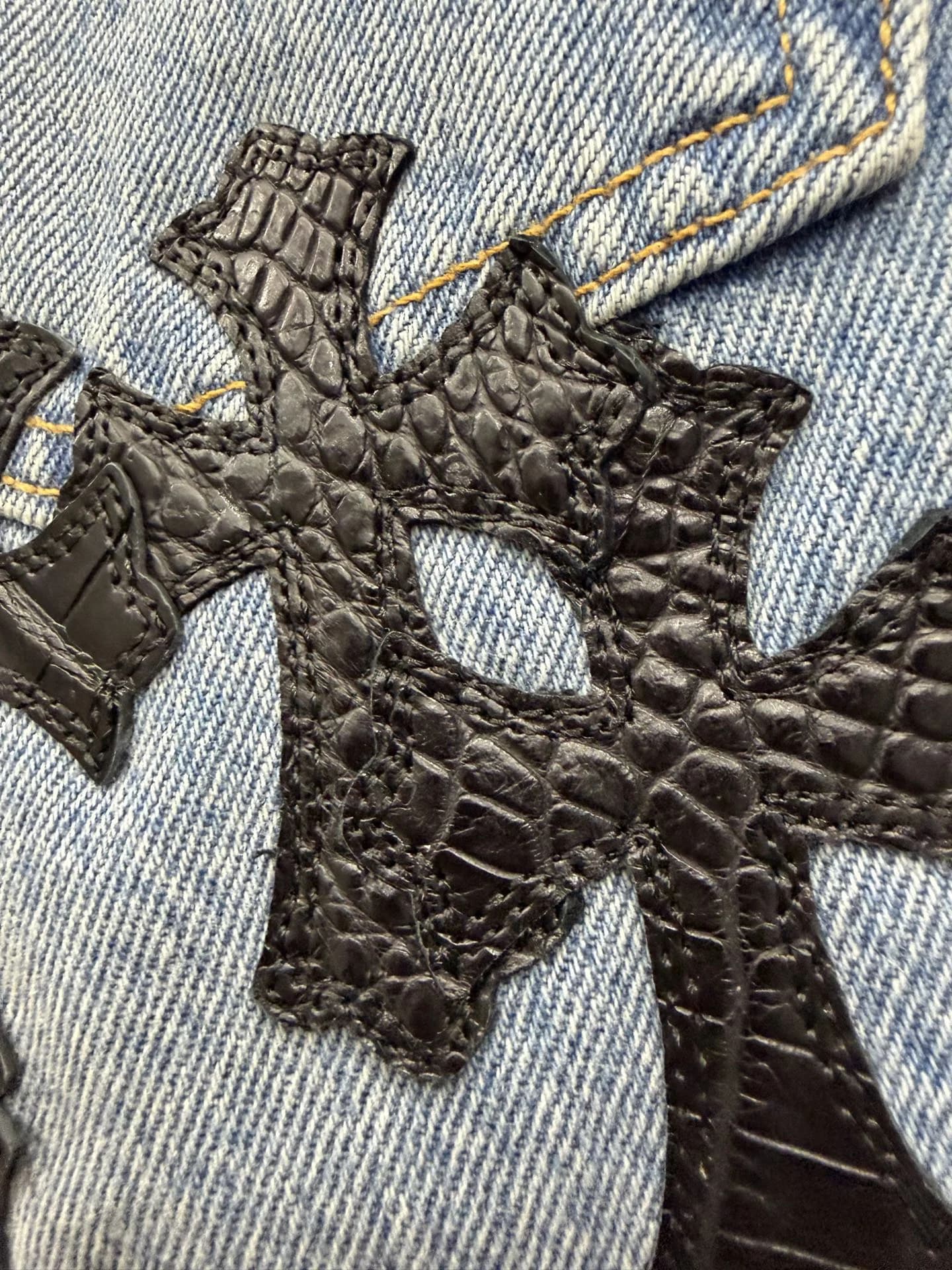Деталь двойной нашивки в виде крестов из кожи крокодила на джинсах Chrome Hearts x Levi's 501