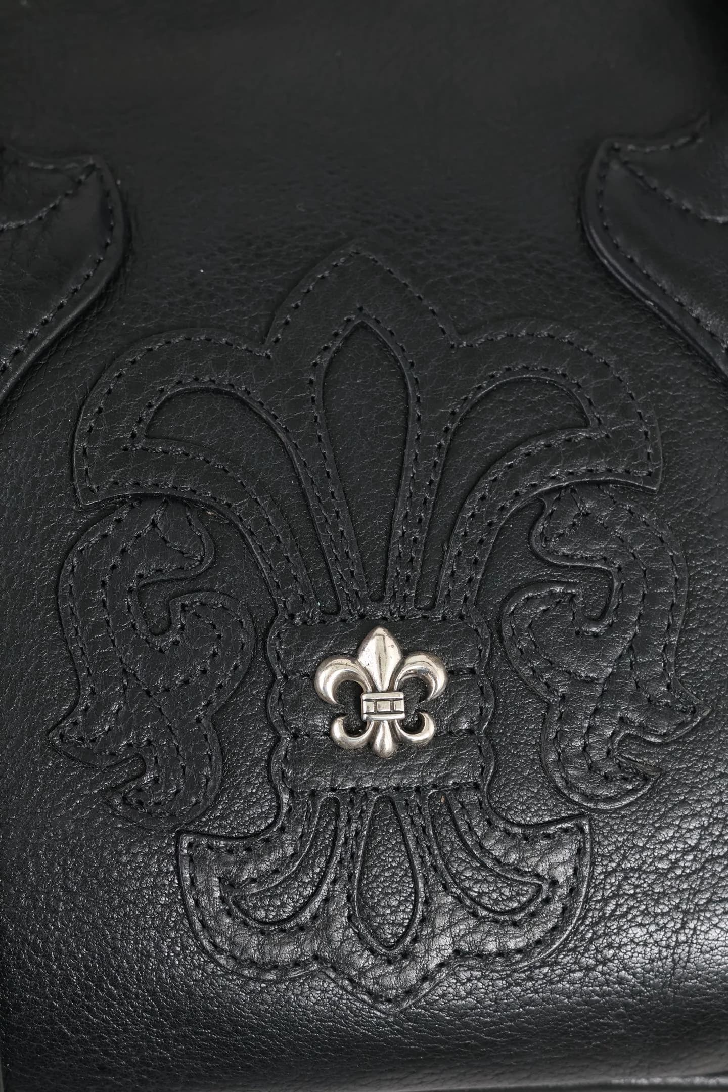 Крупный план кожаной аппликации Fleur-de-lis с серебряной деталью