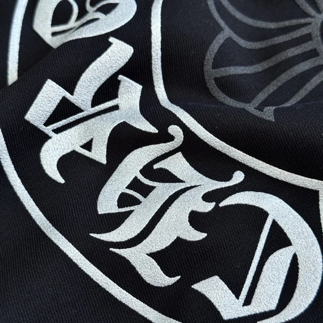 Деталь принта с готическим шрифтом на худи Chrome Hearts
