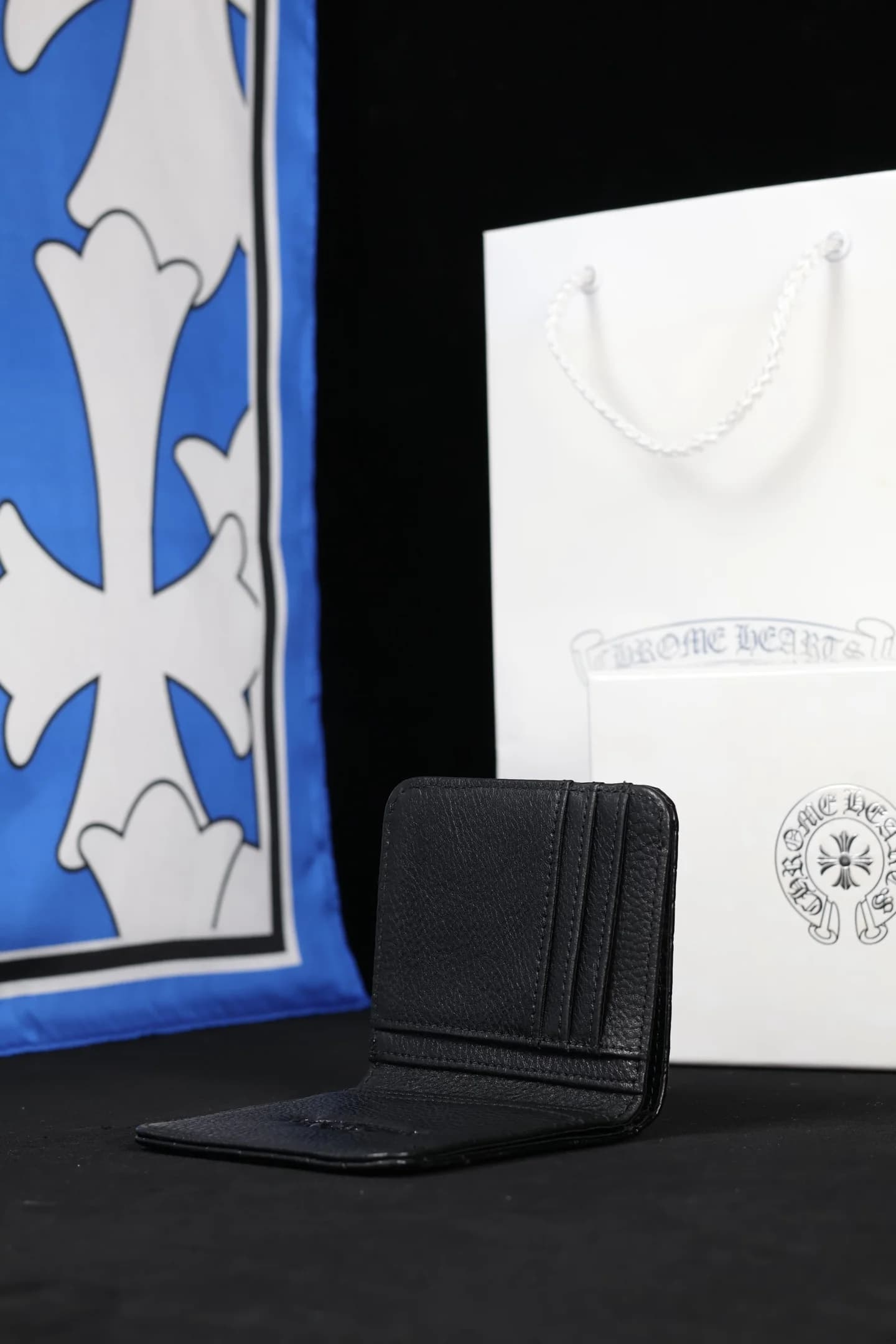 Кошелек Chrome Hearts в полураскрытом виде на темном фоне