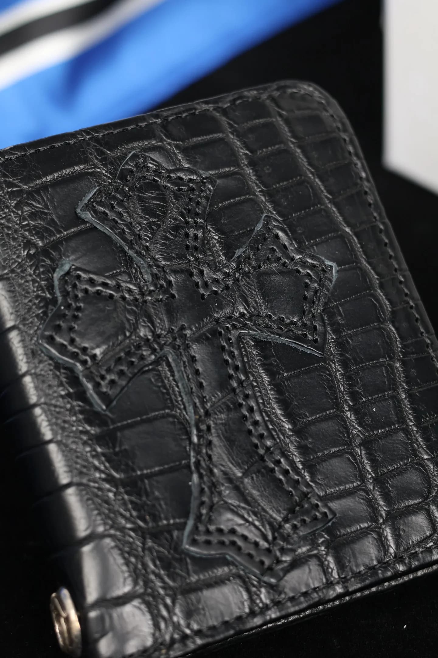 Фактура кожи крокодила и строчка нашивки креста на кошельке Chrome Hearts