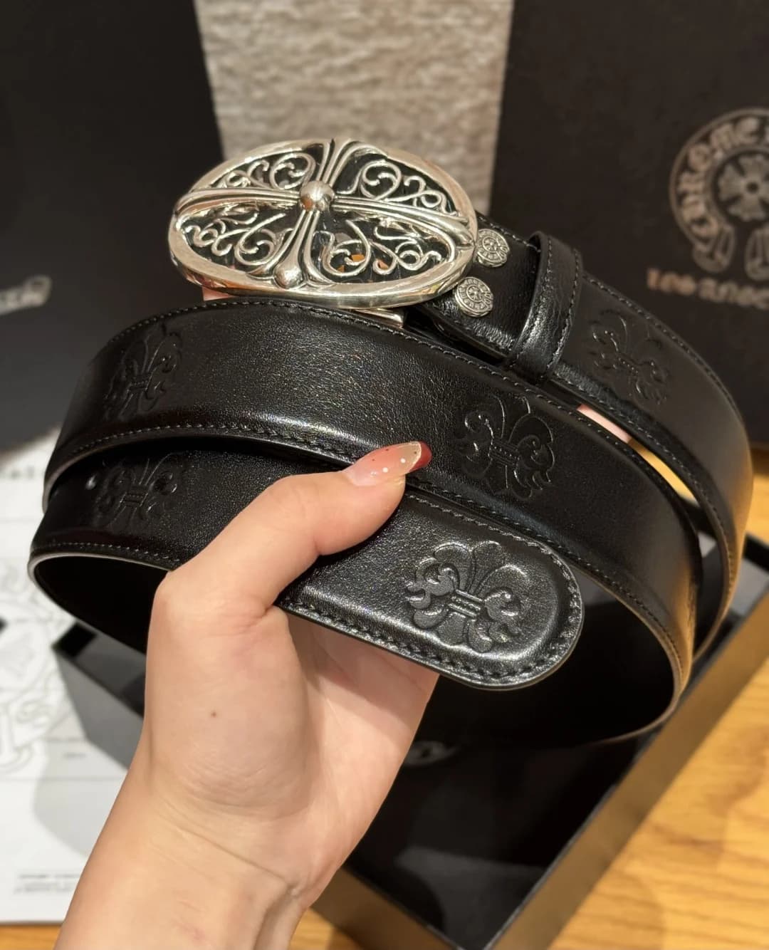 Ремень Chrome Hearts из кожи с тиснением и металлической пряжкой в руке