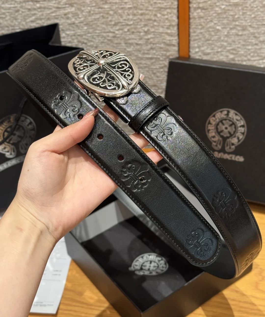 Черный кожаный ремень Chrome Hearts во всю длину в руках