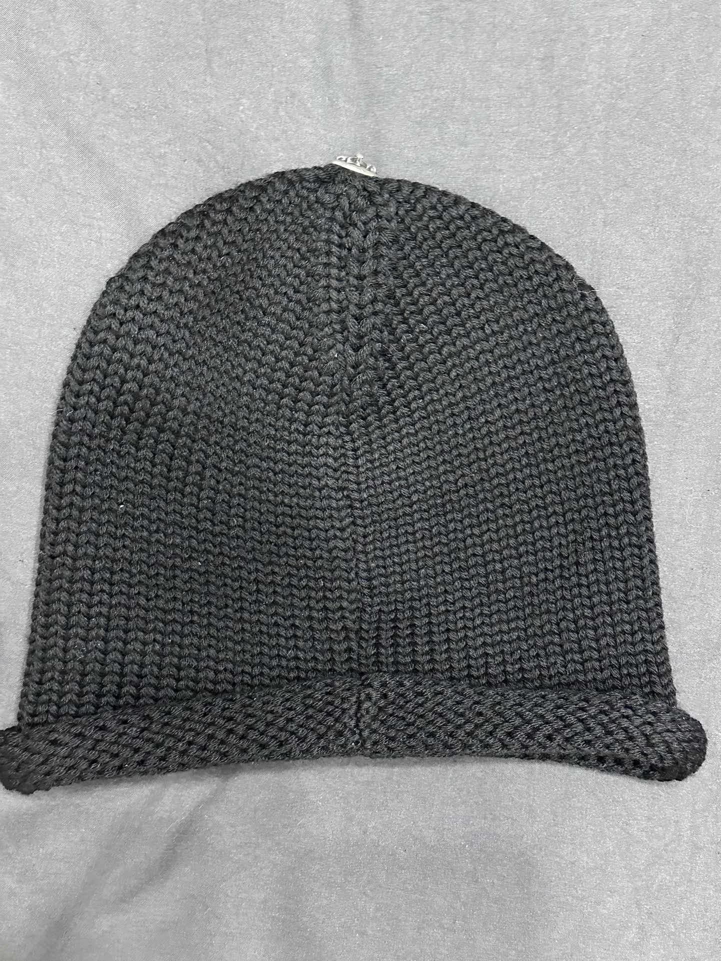 Вид сзади черной вязаной шапки Chrome Hearts