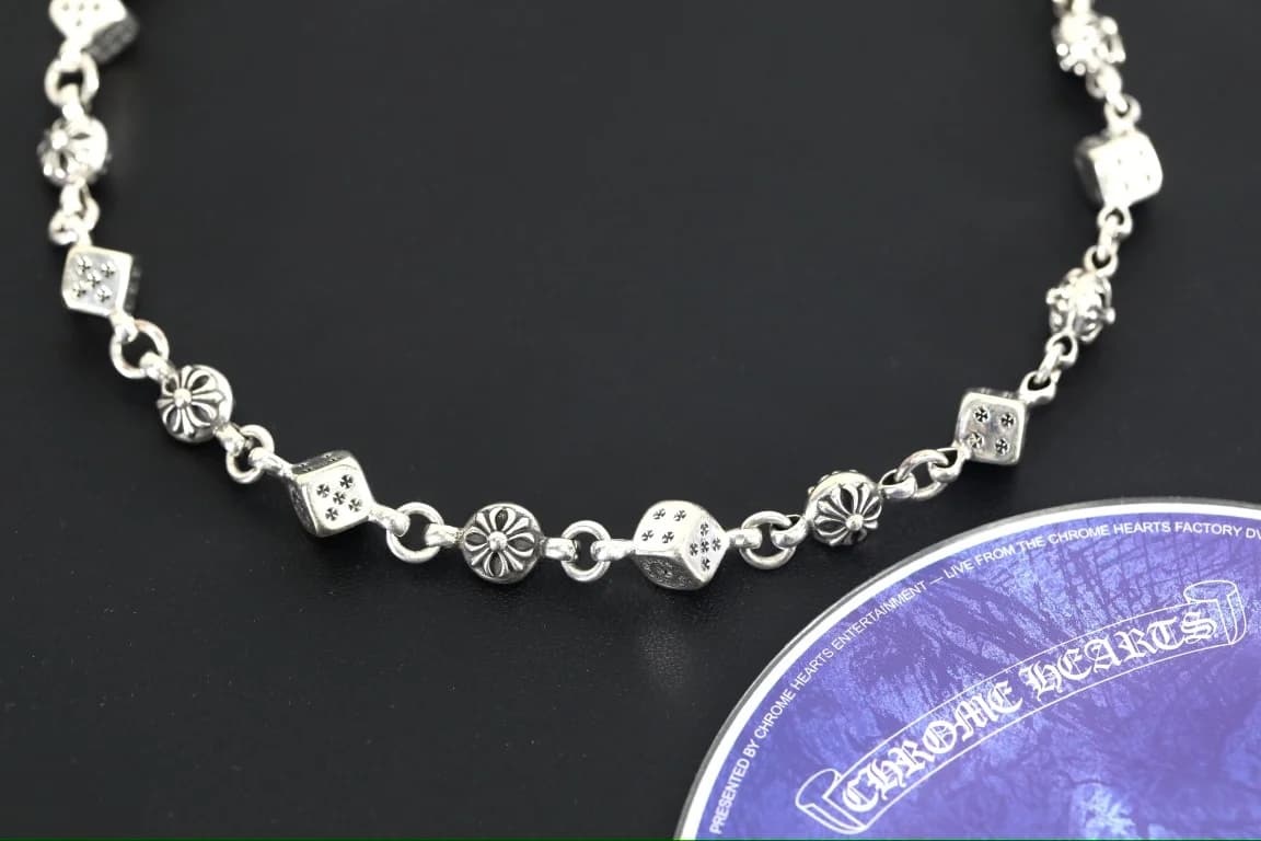 Крупный план звеньев колье Chrome Hearts: кубики и круглые крестовые элементы