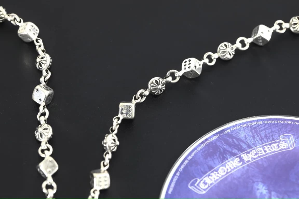 Чередующиеся звенья цепочки Chrome Hearts на темном фоне