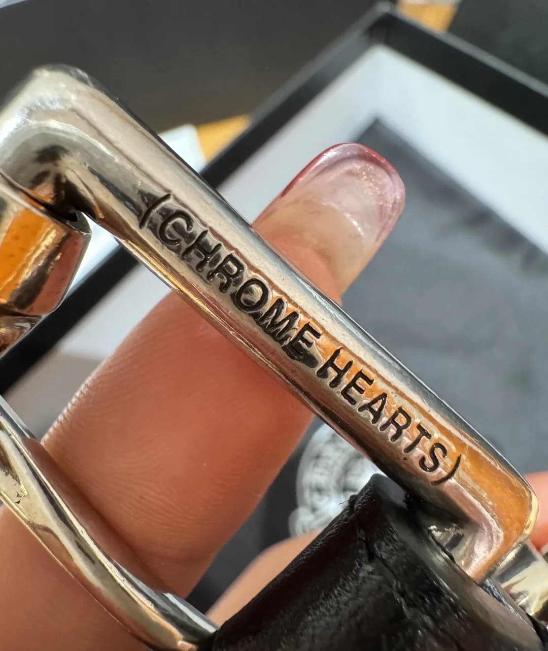Гравировка CHROME HEARTS на серебряной пряжке крупным планом