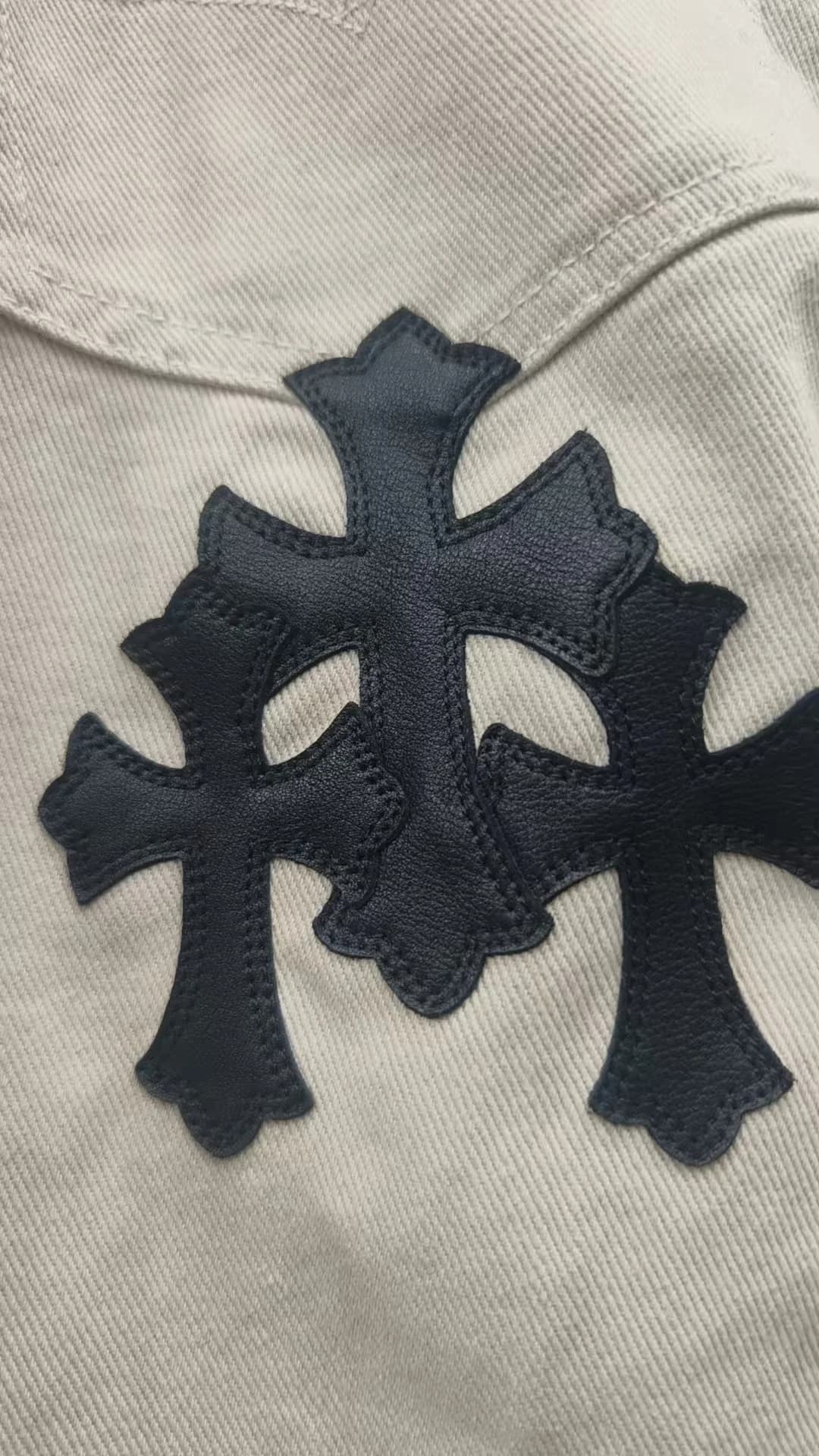 Крупный план черных кожаных нашивок в виде крестов на джинсах Chrome Hearts x Levi's 501