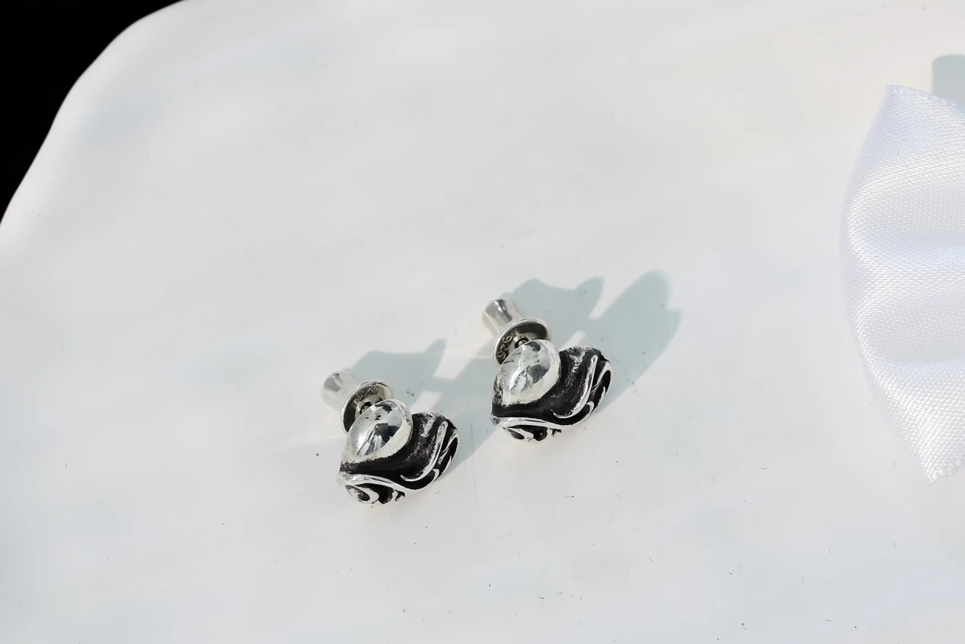 Вид сверху на пару серег-гвоздиков Chrome Hearts Heart