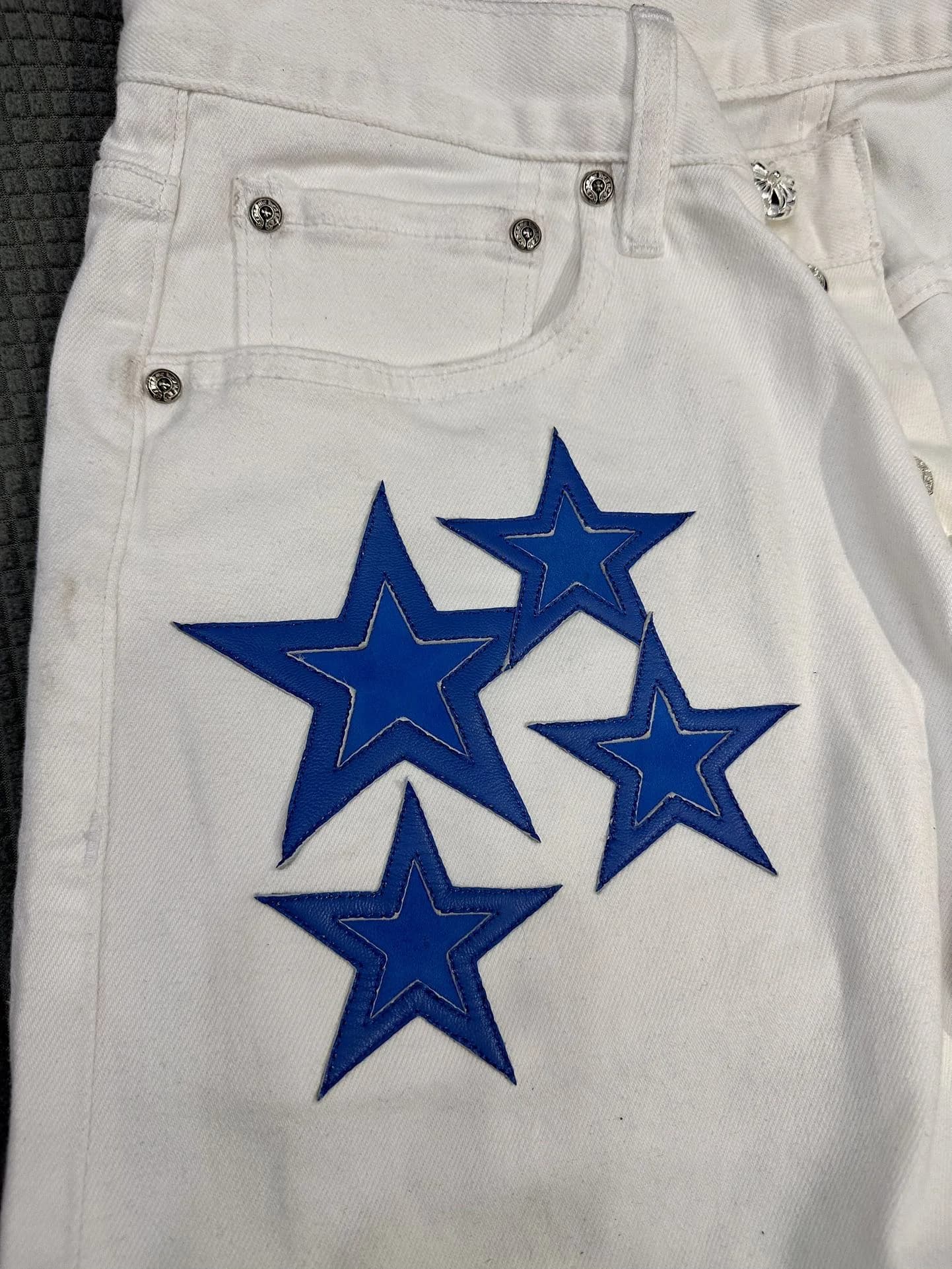 Деталь нашивок в виде синих звезд на джинсах Chrome Hearts x Levi's 501 Vintage