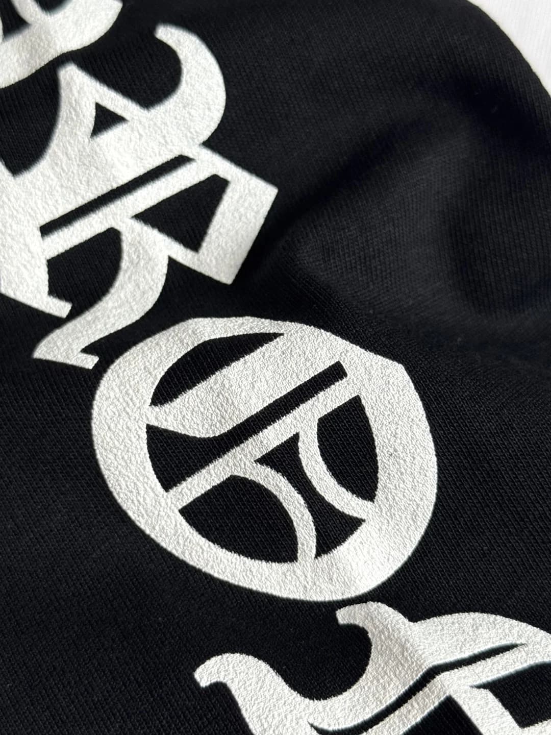 Крупный план текстурного принта на рукаве лонгслива Chrome Hearts
