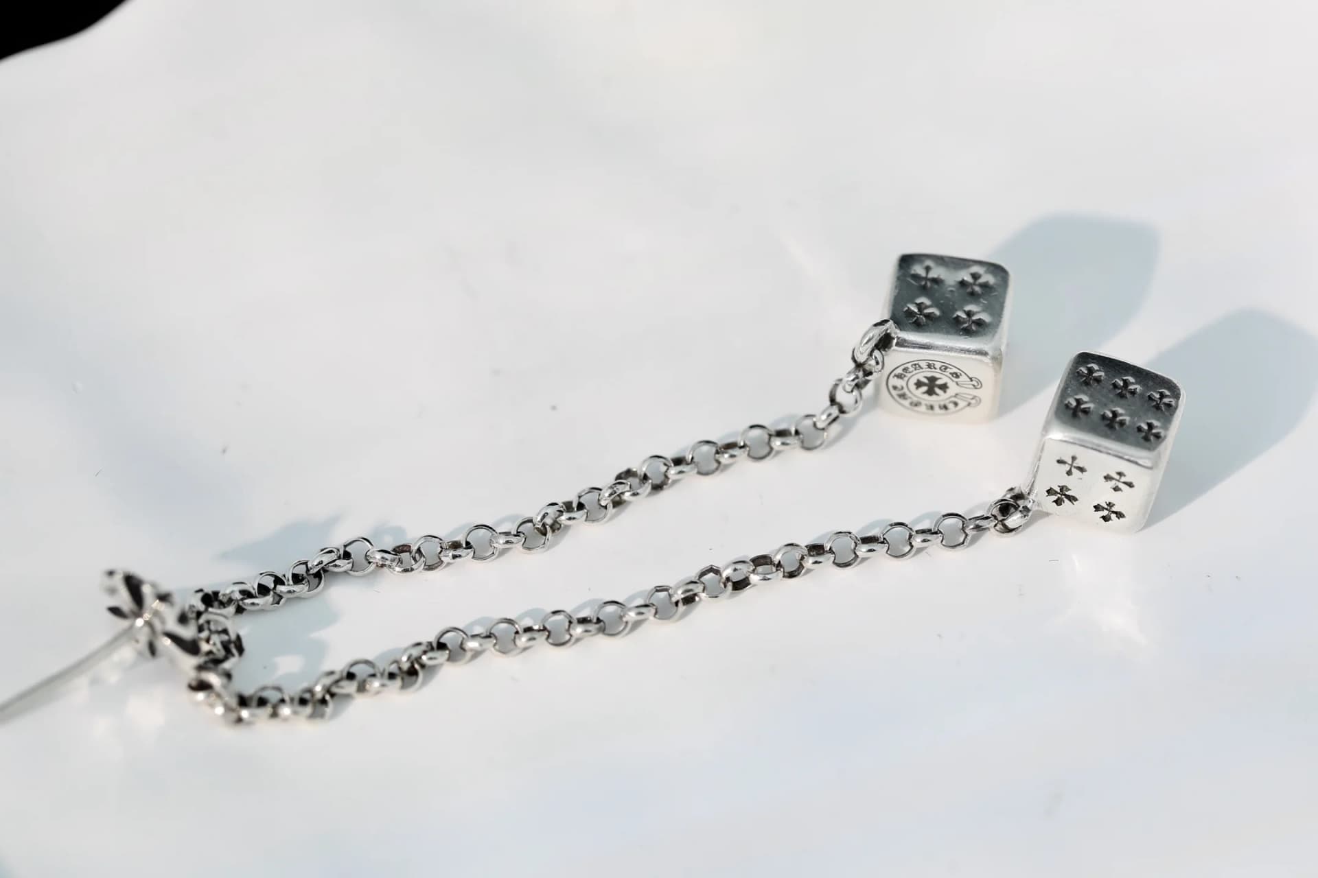 Фактура звеньев цепочки и кубиков серьги Chrome Hearts крупным планом