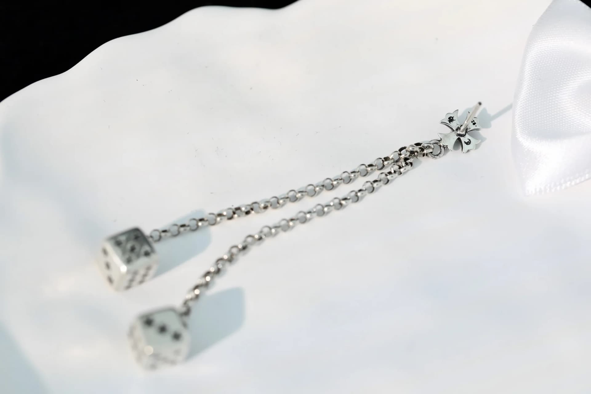 Серьга Chrome Hearts с подвесками dice на светлой поверхности