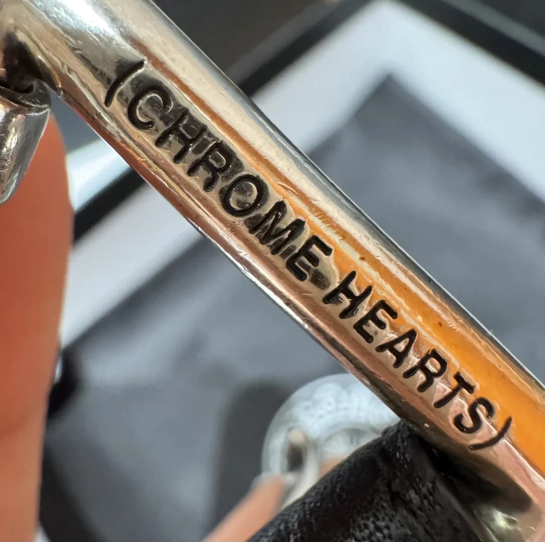Гравировка бренда Chrome Hearts на металлической части пряжки