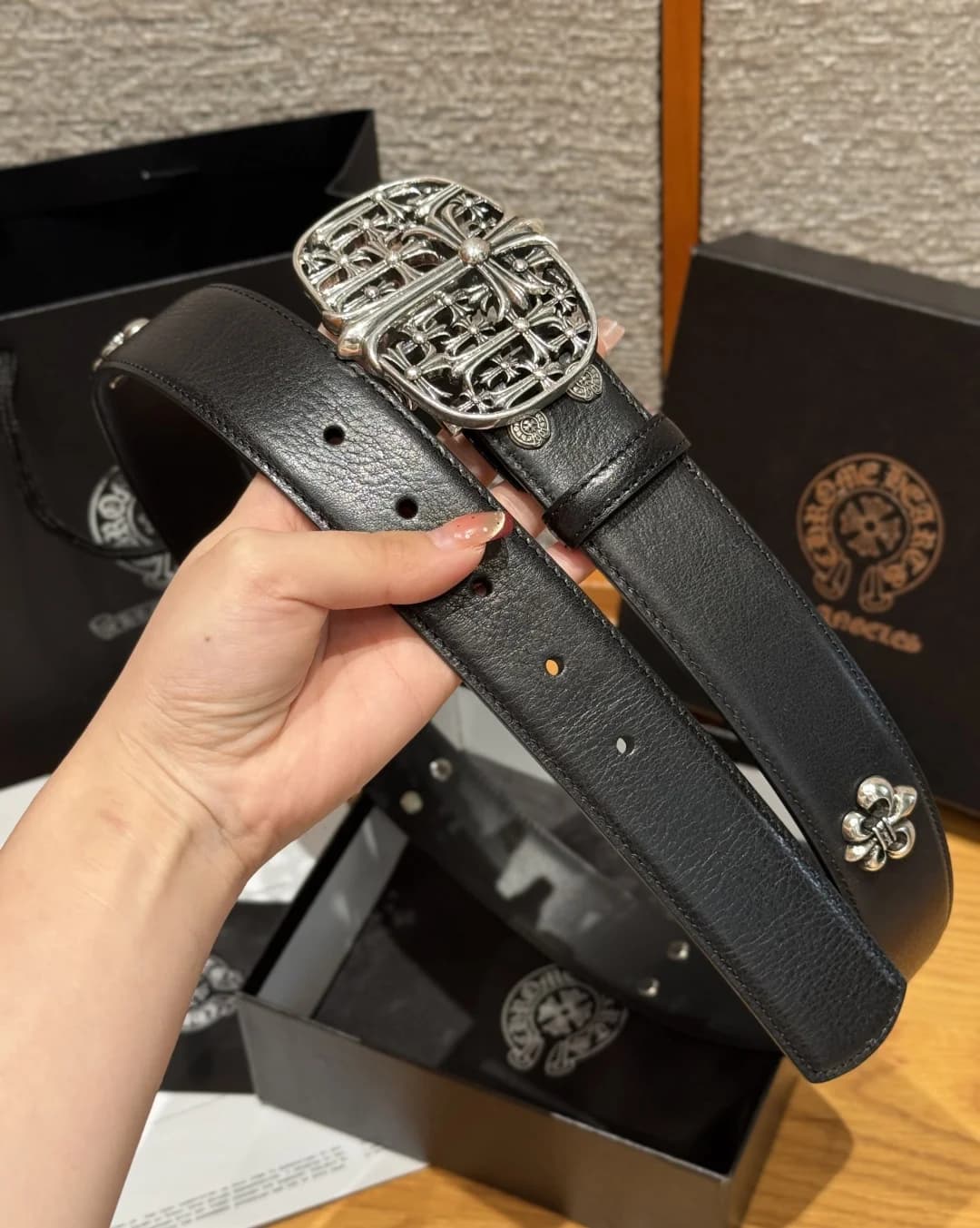 Черный ремень Chrome Hearts из фактурной кожи в руках