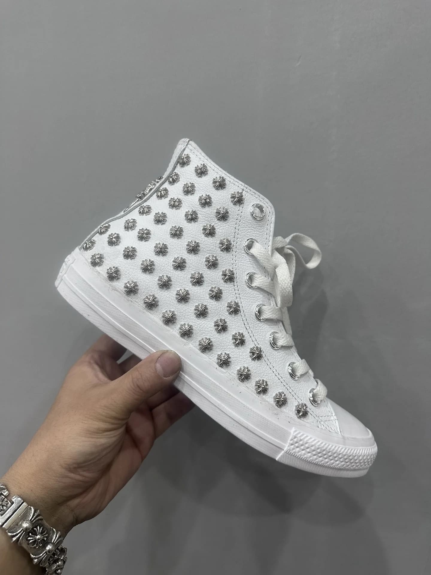 Высокие белые кеды Chrome Hearts x Converse All Star, вид сбоку в руке