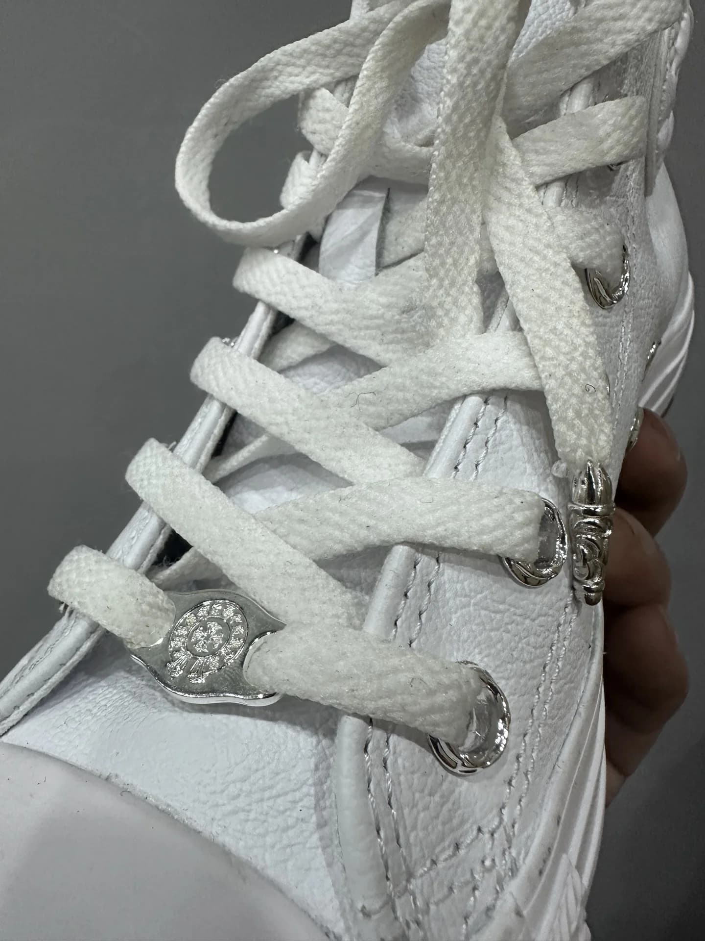 Деталь шнуровки кед Chrome Hearts x Converse All Star с металлической фурнитурой