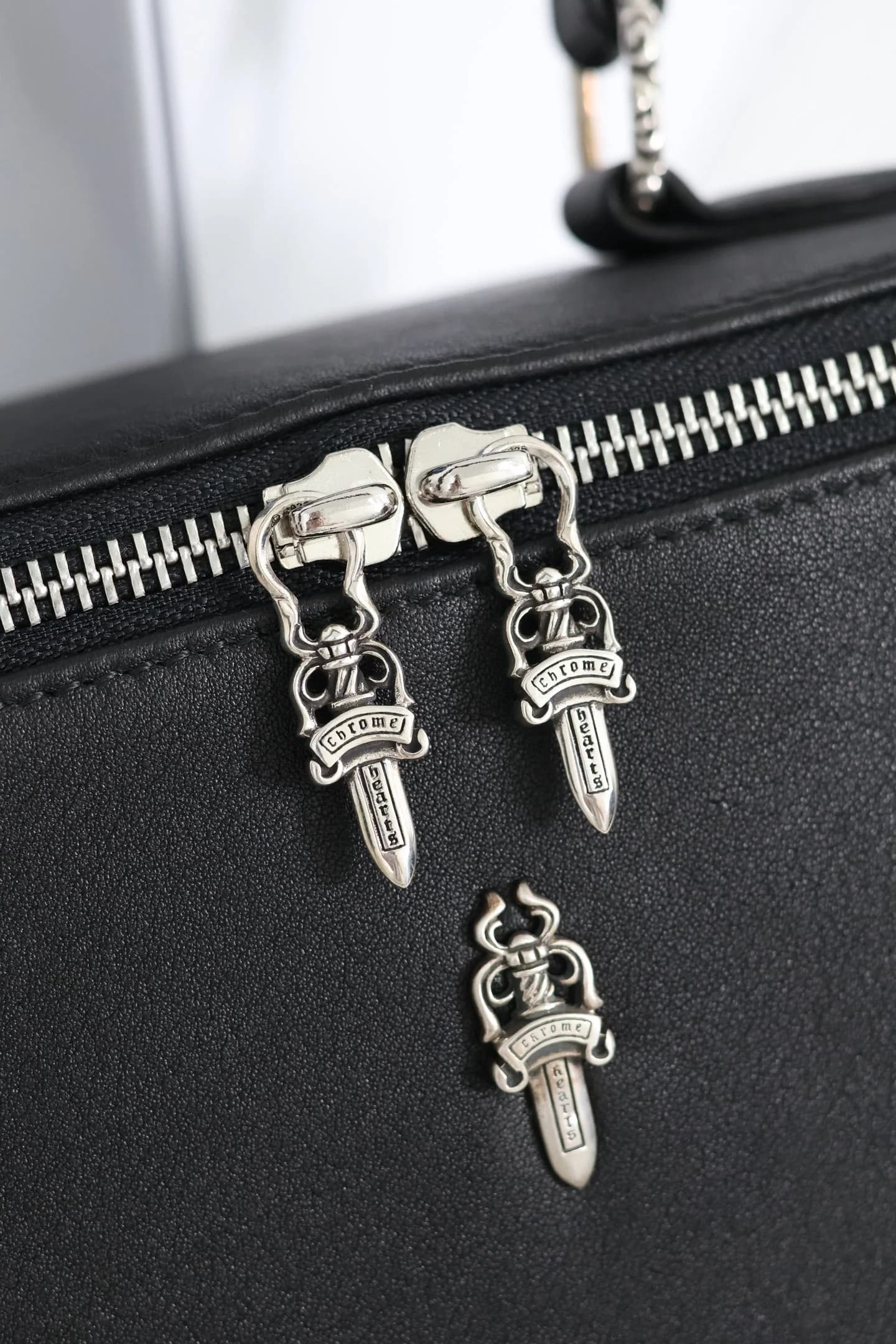 Крупный план серебряных пуллеров Dagger из серебра 925 пробы на молнии сумки Chrome Hearts